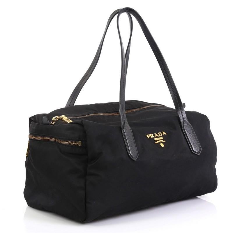 This Prada Zip Satchel Tessuto Medium, crafted in black nylon, features dual leather handles, Prada logo at front and gold-tone hardware. Its zip closure opens to a black fabric interior. 

Estimated Retail Price: $950
Condition: Good. Odor in