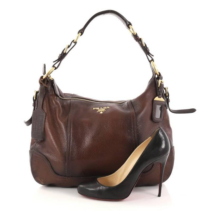 This authentic Prada Zip Top Hobo Cervo Antik Leather Medium is simple, yet regal. Crafted from brown cervo antik leather, this simple elegant bag features a flat leather handle, raised Prada Milano logo and gold-tone hardware accents. Its zip