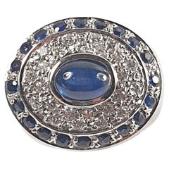 Pradera-Ring mit einem zentralen Saphir und kleinen Saphiren und Diamanten