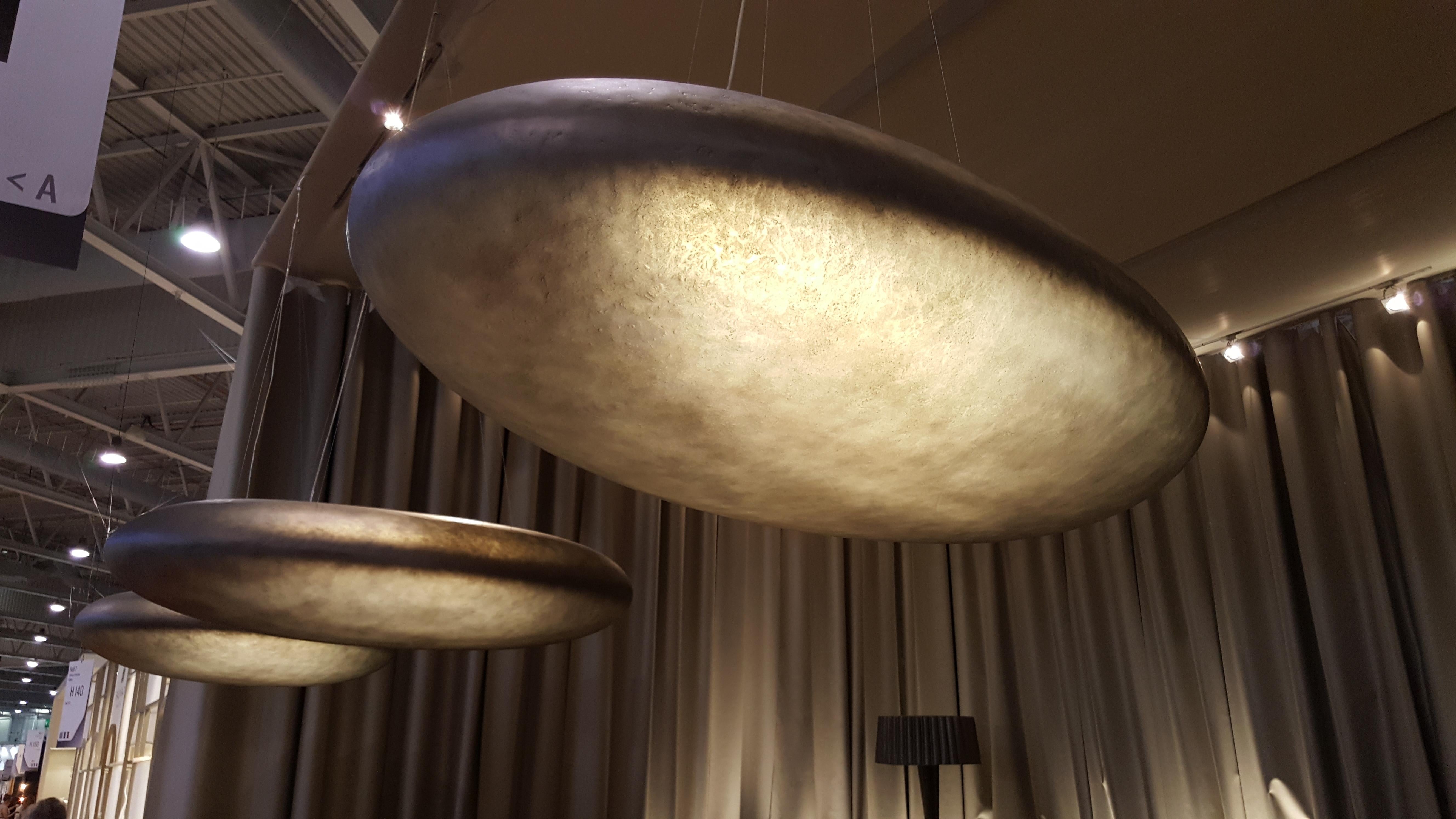La lampada da soffitto Praia incarna l'eleganza organica dei ciottoli lisci e consumati dal tempo di Madeira. Disegnato da Nini Andrade Silva, questo apparecchio scultoreo trasforma la fibra di vetro in un'opera d'arte radiosa, diffondendo una luce