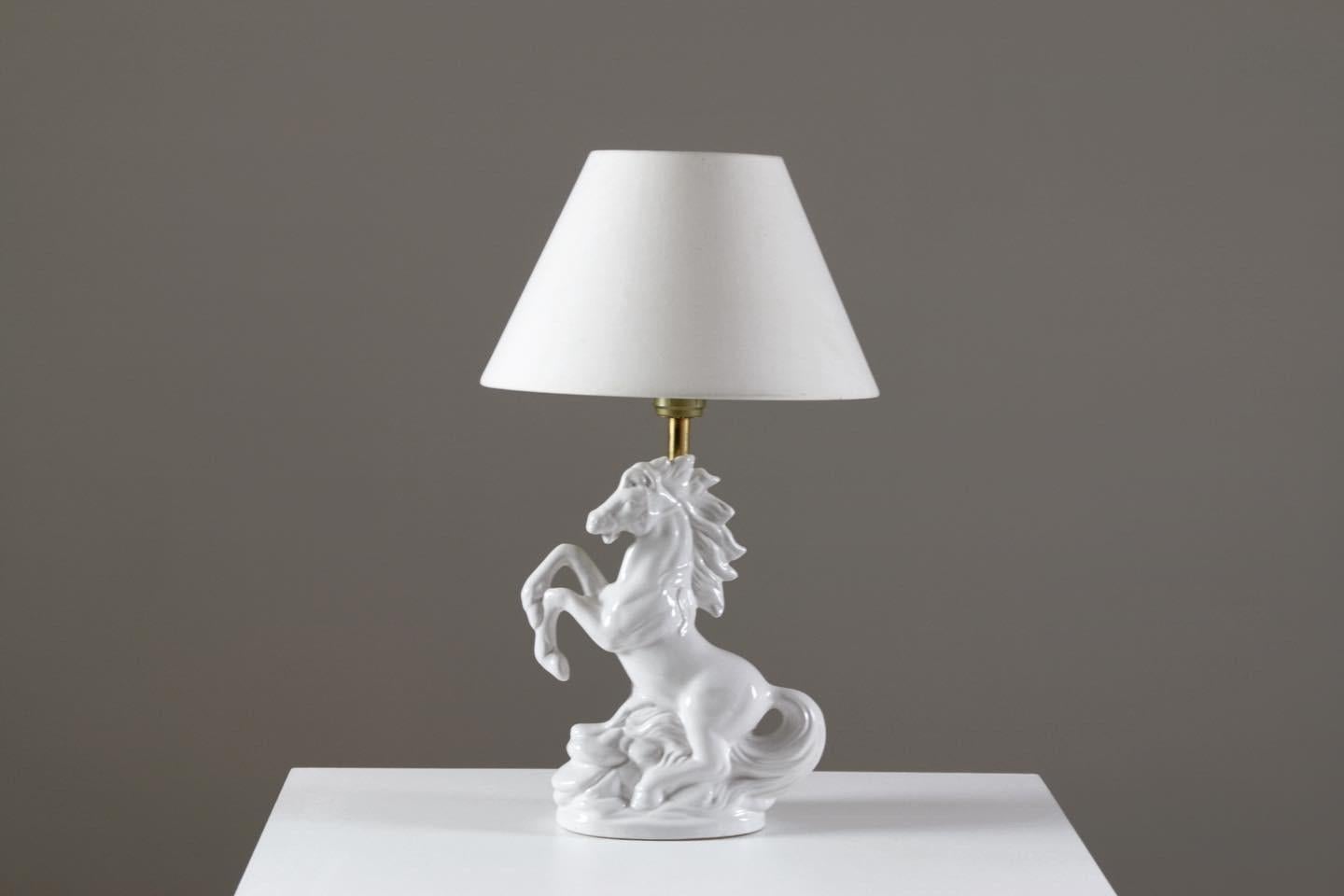 Lampe en céramique représentant un cheval blanc cabré. Très décoratif et en très bon état. Dimensions : D42 X W22 X H12 cm.