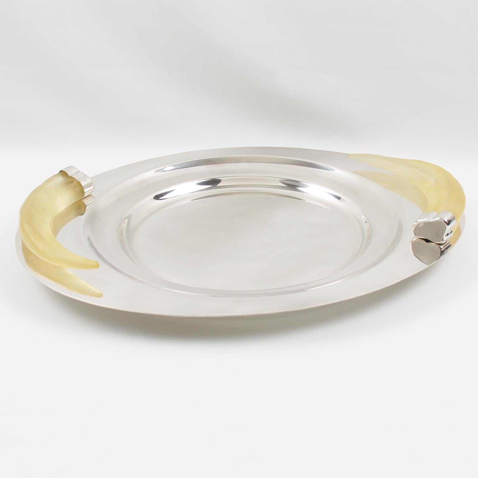 Adéntrate en el mundo de la sofisticación atemporal con esta exquisita bandeja para servir, una auténtica obra maestra diseñada por la orfebre Prata Wolff en la década de 1980. Este plato ovoide con baño de plata, un sorprendente ejemplo de arte