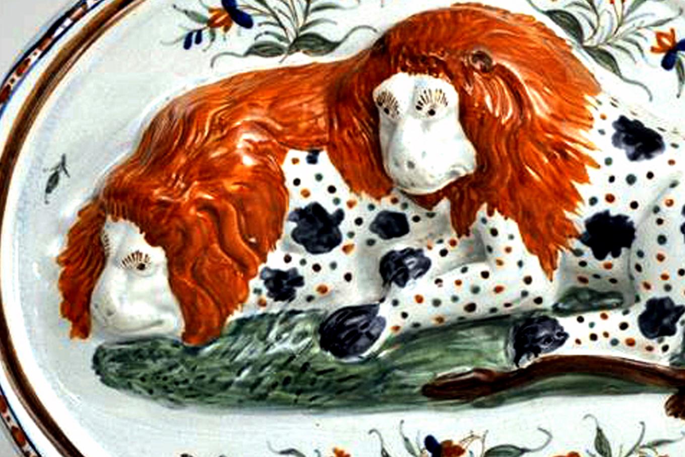 The Prattware pearlware plaque is relief-mouded with two recumbent lions and painted in under glaze colors with floral branches and a molded border. What is so nice about this particular plaque is that it has wonderful folky blue colors on the