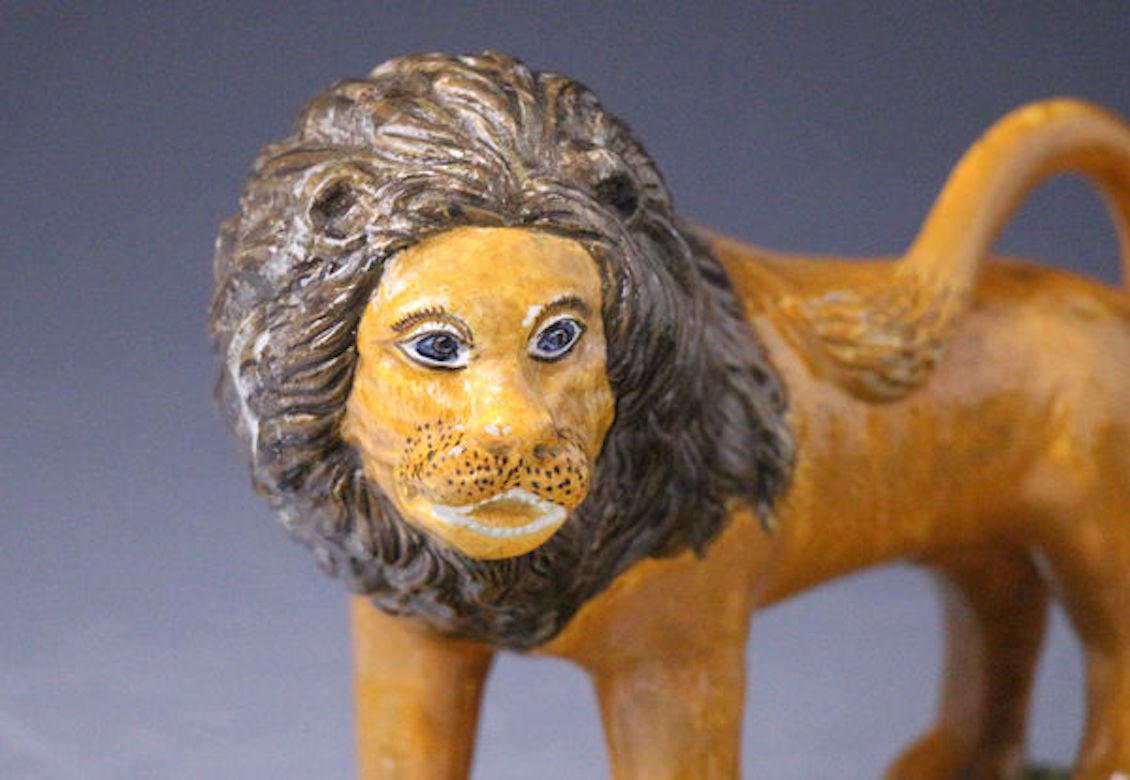 Prattware pottery figure of a standing Lion on a green grassy base early 19th century, circa 1800.

A rare Prattware pottery figure of a male lion standing on a green grassy base. The body of the lion decorated in ochre with a dark brown mane. The
