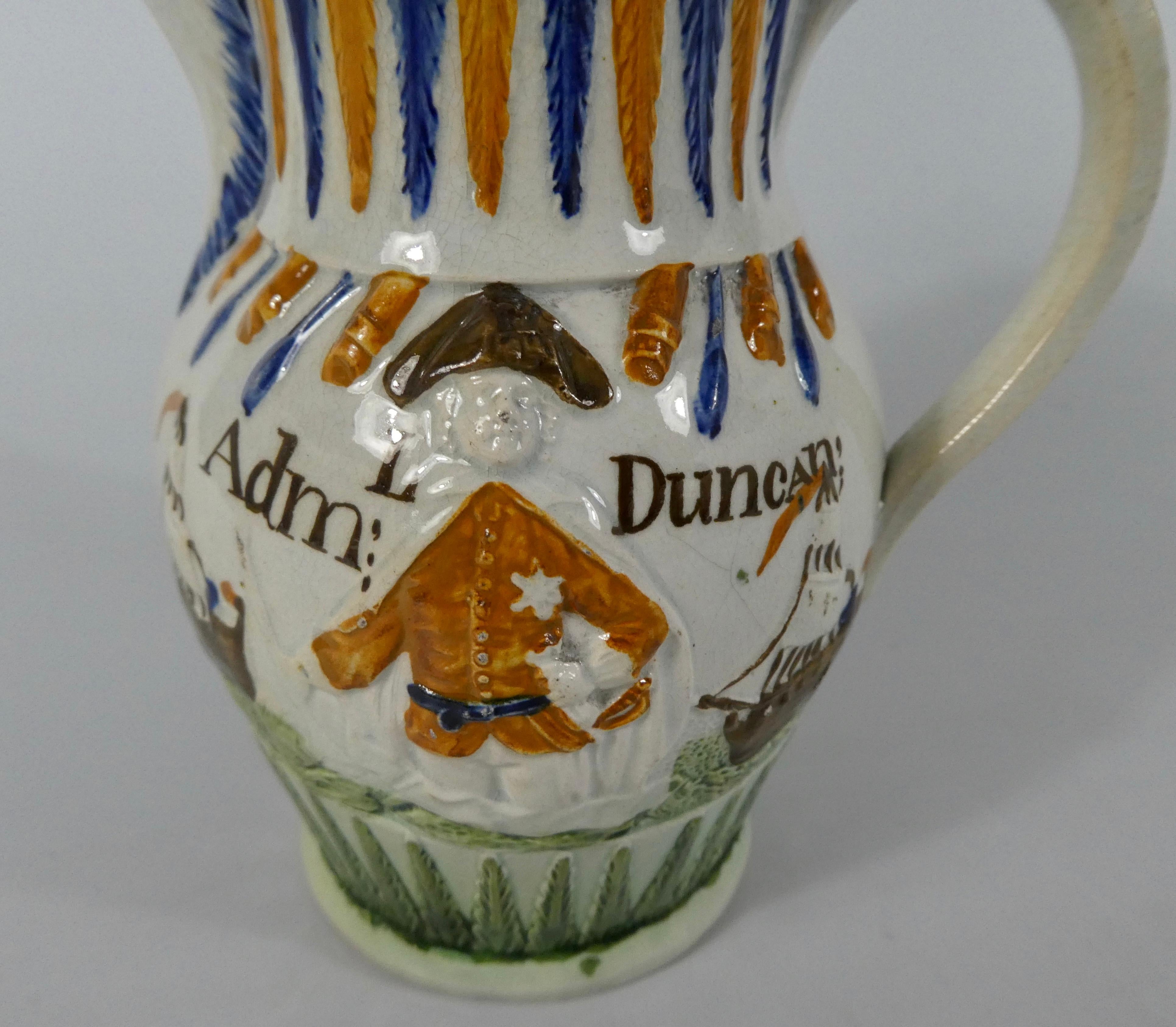 Staffordshire pottery ‘Prattware’ jug, circa 1798. Made to commemorate Admiral Duncan, and his role at the Battle of Camperdown. Moulded to both sides, with three quarter length portraits of Admiral Duncan above dolphins, and between ships. The base