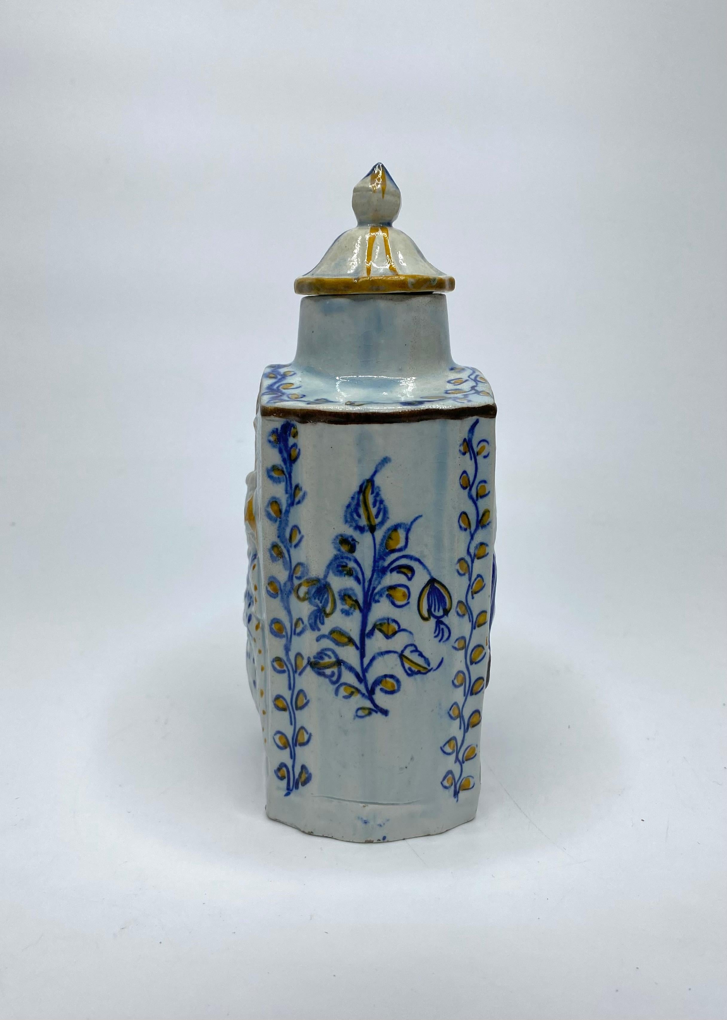 English pottery Prattware ‘Macaroni’ tea caddy and cover, c. 1800. Moulded to one side with ladies of high fashion, in elaborate 18th Century costume, whilst the reverse shows their male counterparts in appropriate attire. Hand painted in vibrant