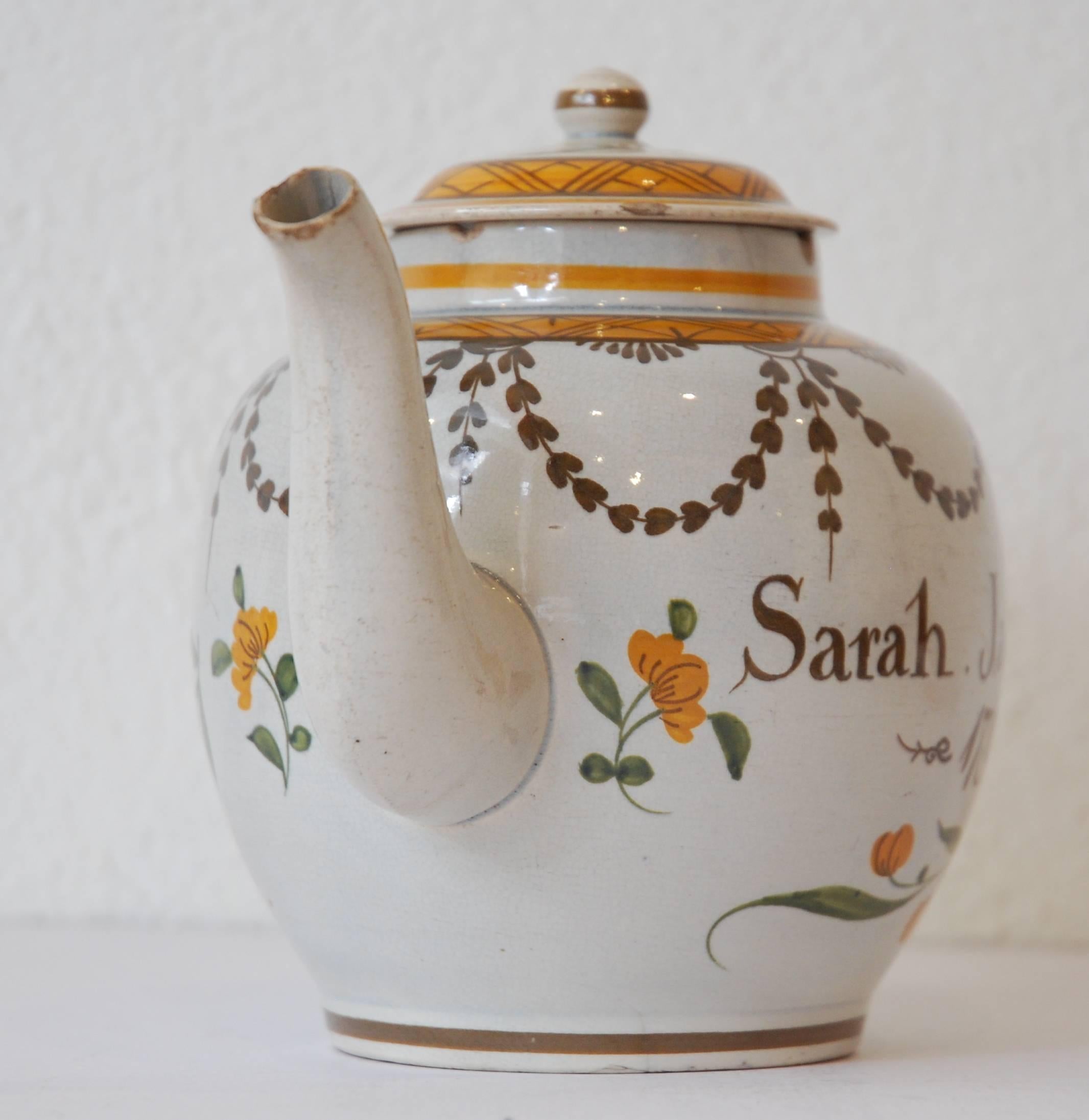 A documentary teapot, in pearl ware with Pratt ware colors under glaze. Dated and inscribed for Sarah Jackson. Attributed to the Swinton Pottery.