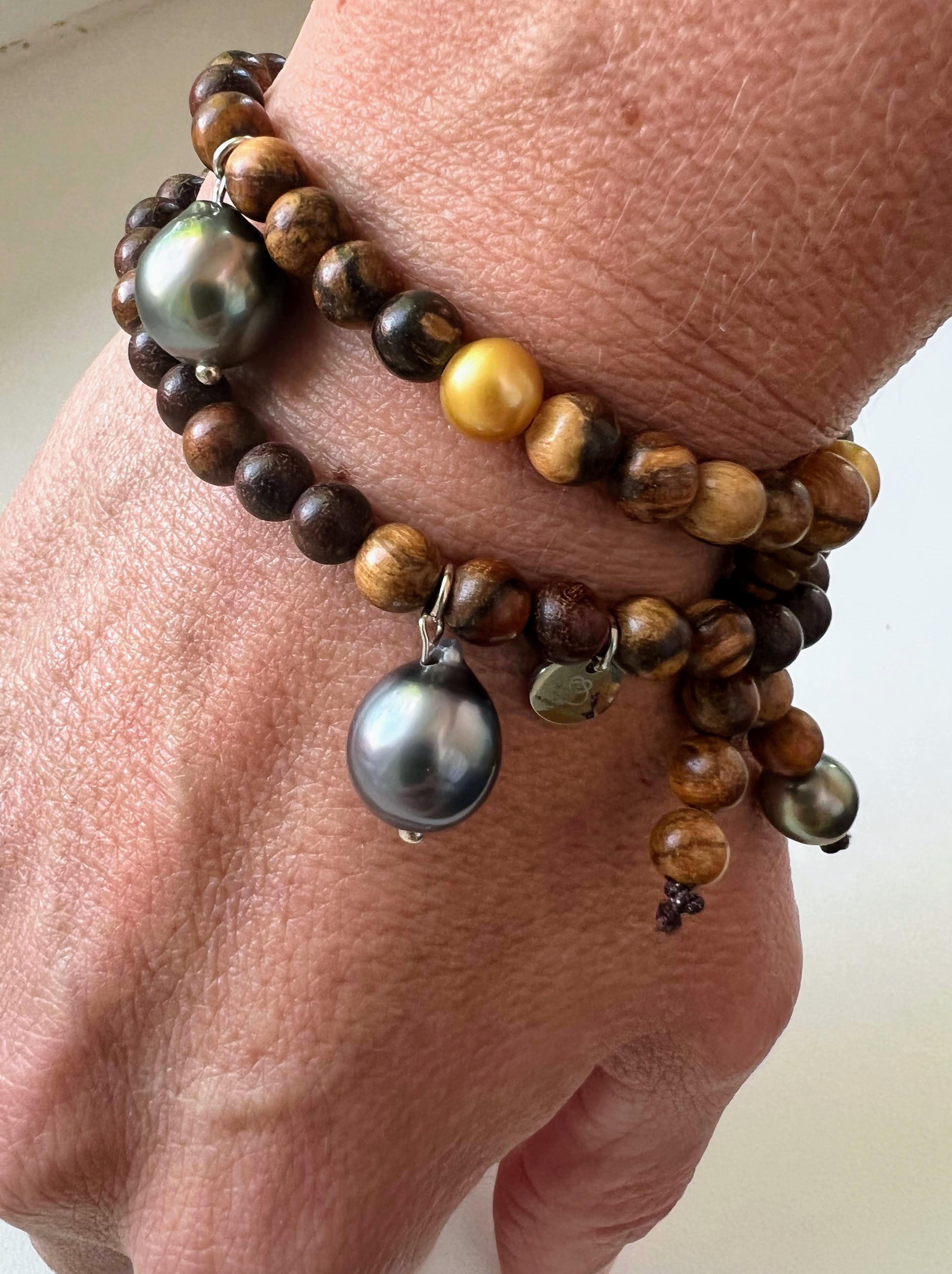 This jewelry piece is inspired by the Buddhist prayer bracelets. It can be worn as a short necklace or wrapped around the wrist. It is captivating with its intriguing little and rare golden pearls. The dangling Tahiti pearls in baroque shape add a