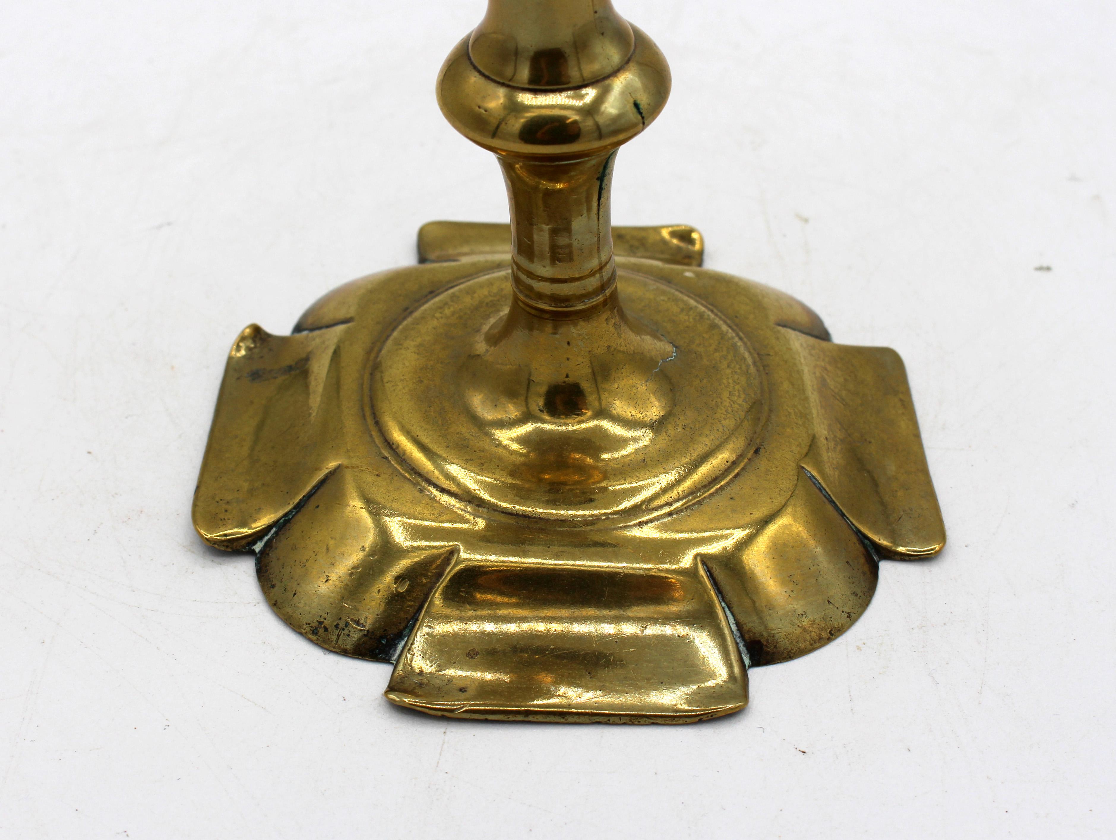Englischer Messing-Kerzenhalter aus der Zeit vor 1740 (Georg II.). Achteckige Blütenblattbasis; die Seiten bilden große, flache Blütenblätter mit gewölbten Eckblättern. 2-teiliger Guss. Oben in der Basis gespalten.
7,75 x 4 3/8