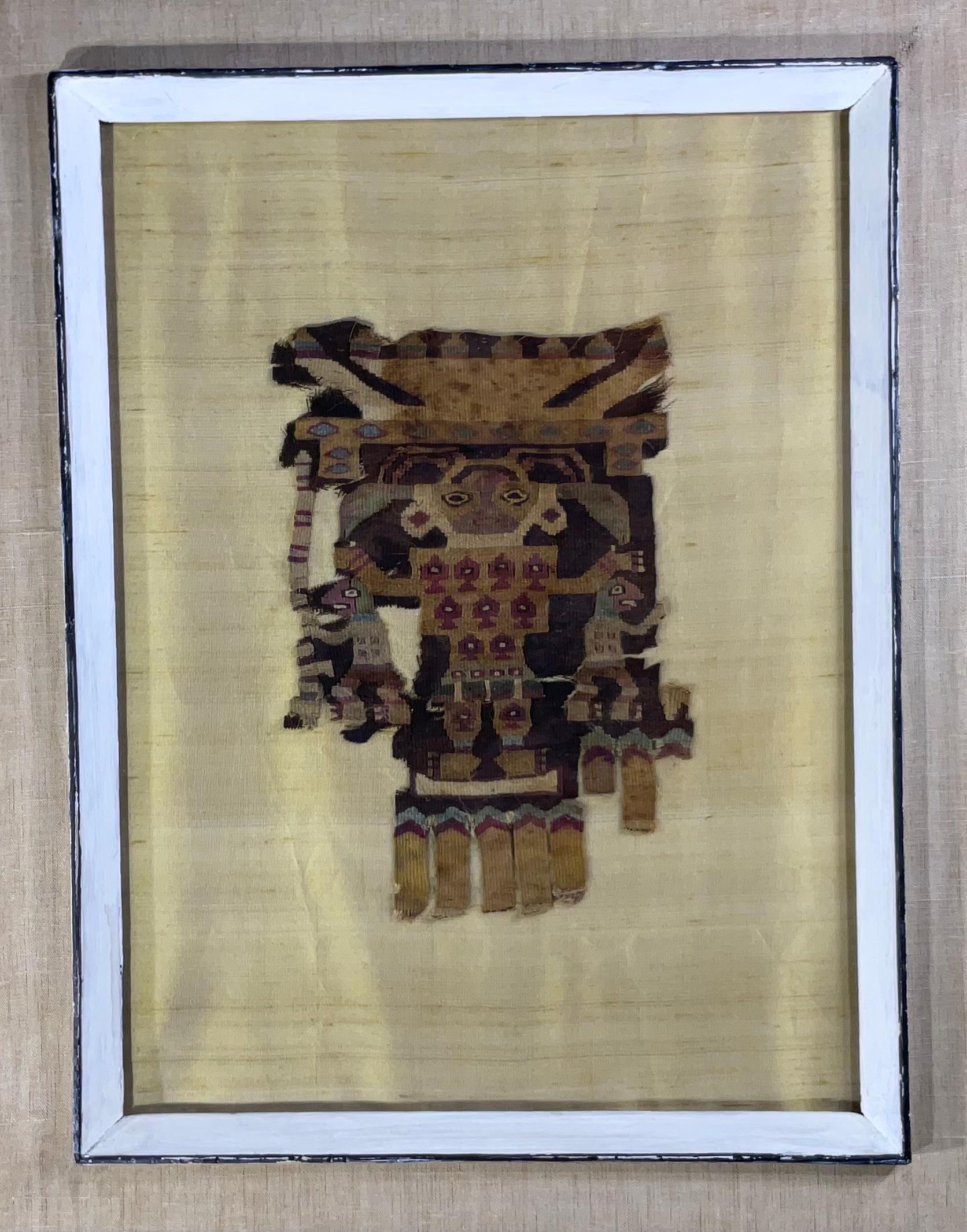 Fragment de textile tissé à la main de qualité muséale, présentant un motif humain, royal ou martien, monté professionnellement sur soie matte, dans un cadre en bois vintage très décoratif servant de boîte à ombres. Le textile est daté de la fin de