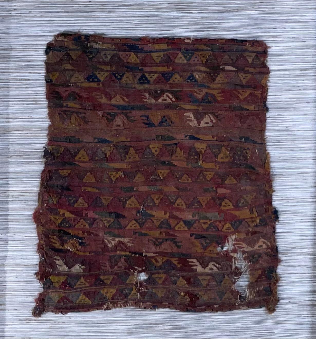 Museum quality handwoven textile fragment, featuring human faces  ,or geometric motifs , professionally mounted on cotton matte , in very decorative wood frame as shadows box . The textile dated from late horizon -early colonial AD 1476 to 1600 slit