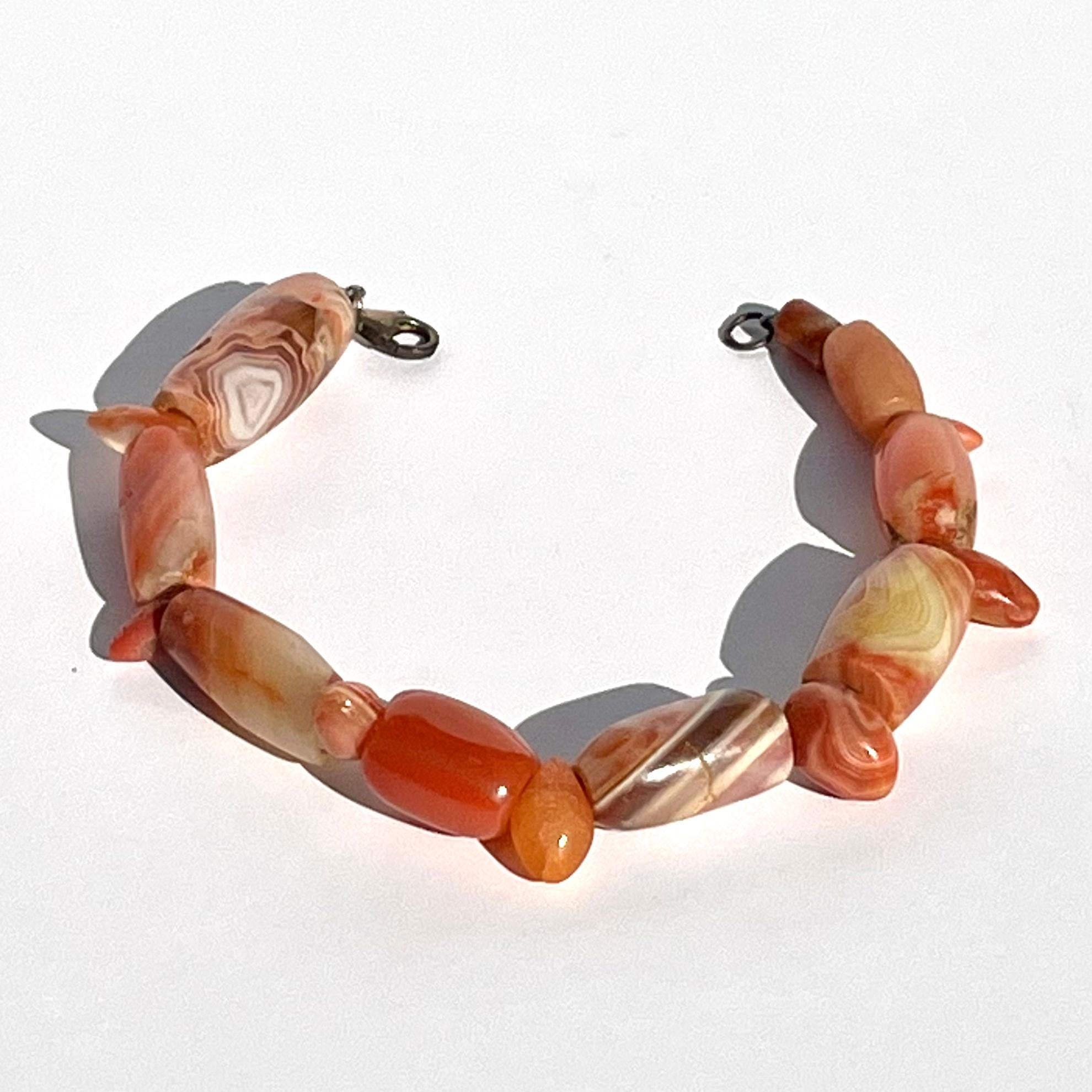 Circa 1000 - 1500 CE Pre Colombian. Columbia, Tairona. Beads.

A lovely bracelet of a wearable comprised or 17 seed form, tubular and ovoid beads carved form vermelian hued carnelian. The integral white veining running throughout the stones