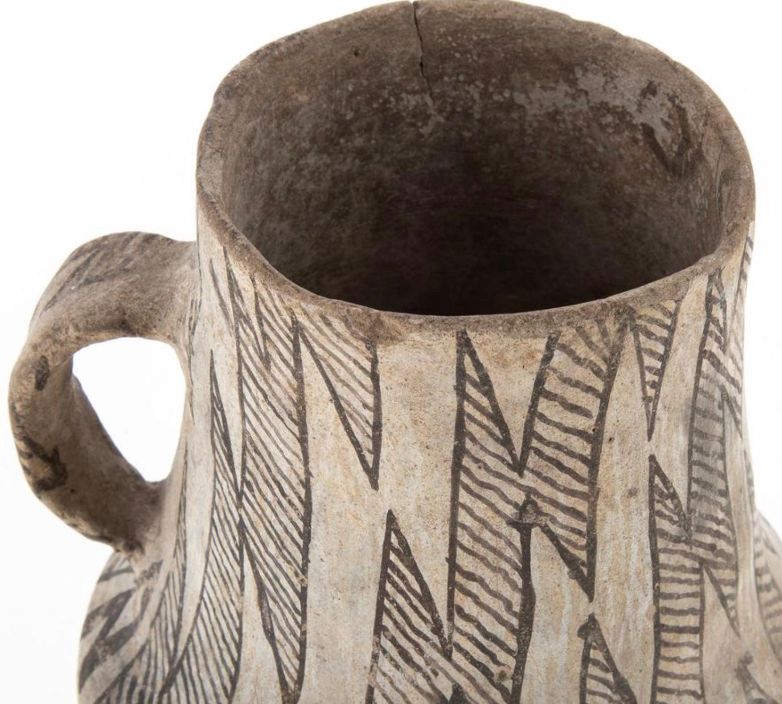 A very nice and intact Anasazi black on white Snowflake pitcher with painted basket geometric design around body. Remains in as found condition. A rare intact, large pottery pitcher, painted in the style most commonly excavated at the great Anasazi