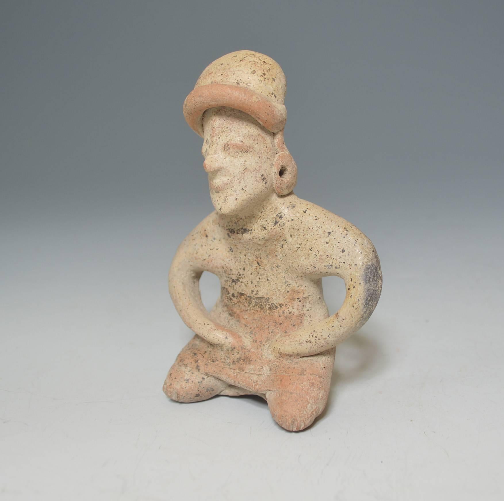 A pre Columbian ancient Mexico Nayarit figure, BC 200–AD 200 

A male seated solid body pottery figure with head band and earrings

Measures: Height 16 cm

Condition: good

Ex UK collection before 1960.