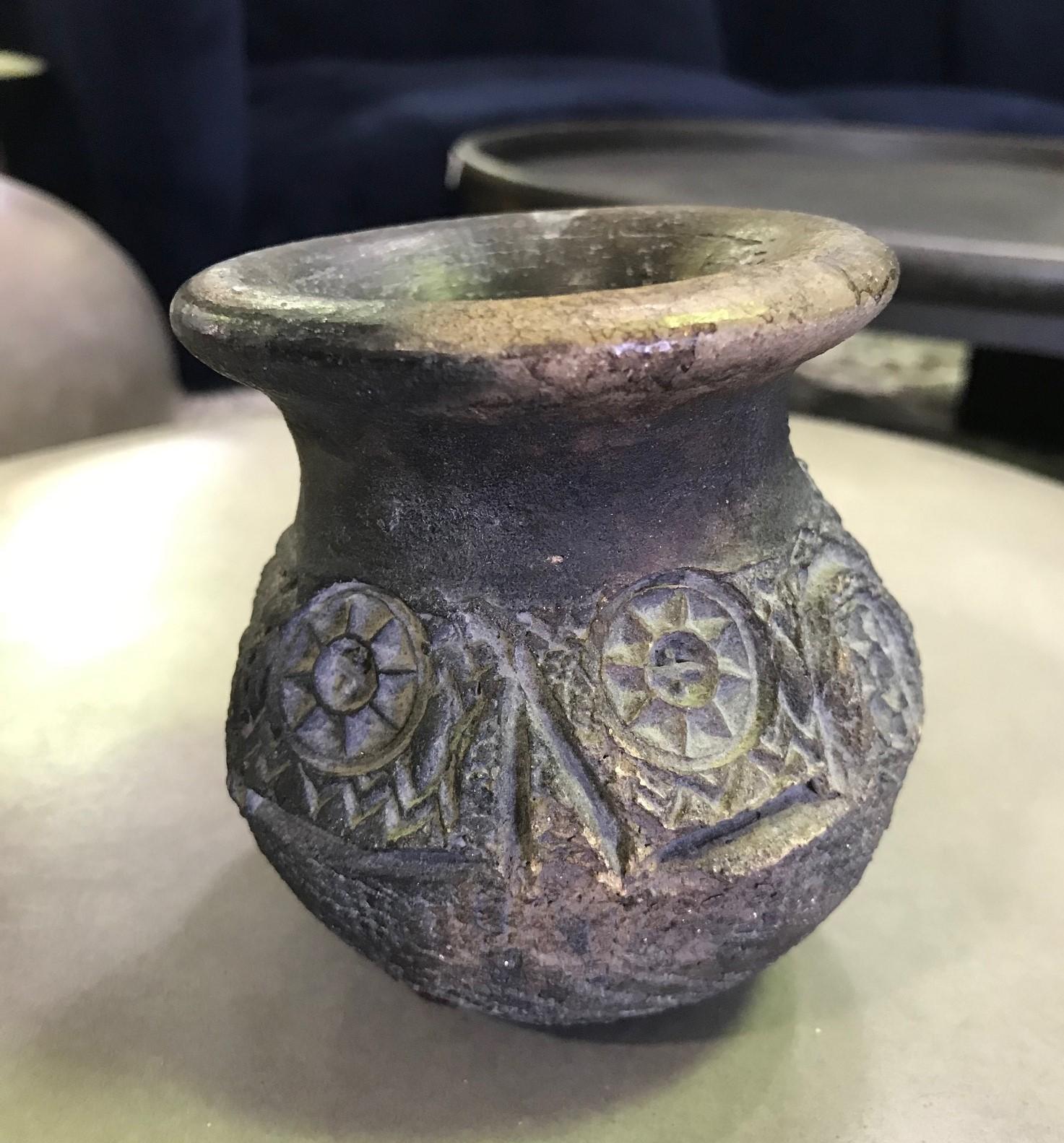 A strange and beautifully designed Pre-Columbian blackware cup or vase/vessel though a bit uneven/ lopsided. Gives it character. 

Well crafted with a nice patina. Comes from a collection of primitive and tribal artifacts along with three pieces
