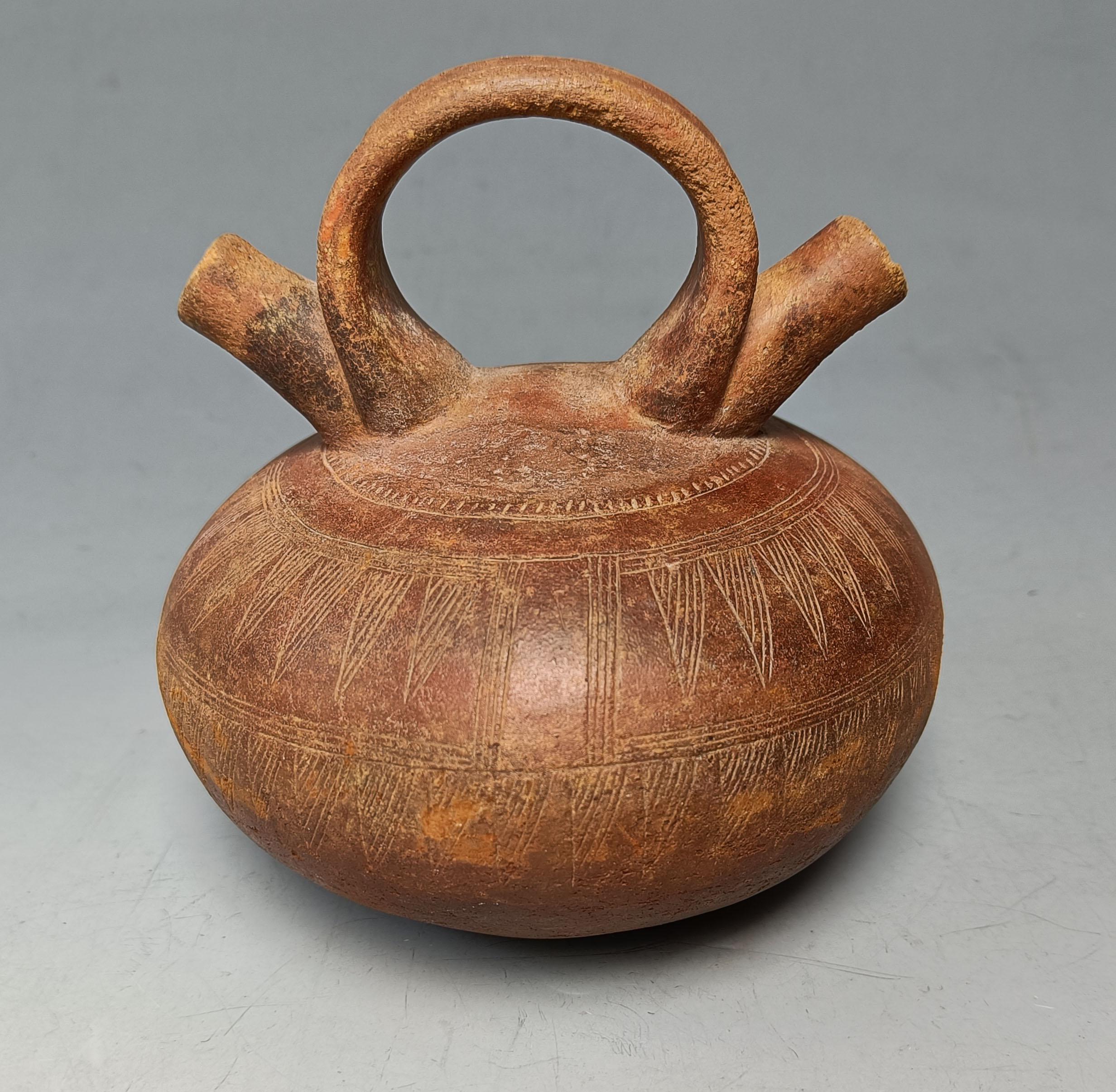 Pre-Columbian navire Calima Colombie ancienne Amérique du Sud 
Vase Calima à double bec et à étrier avec des motifs incisés en argile rouge
 
Calima vers 200 BC- 400 ADS Colombie
Condit : fissure mineure, pas de restauration,  
Taille Hauteur 16 cm,