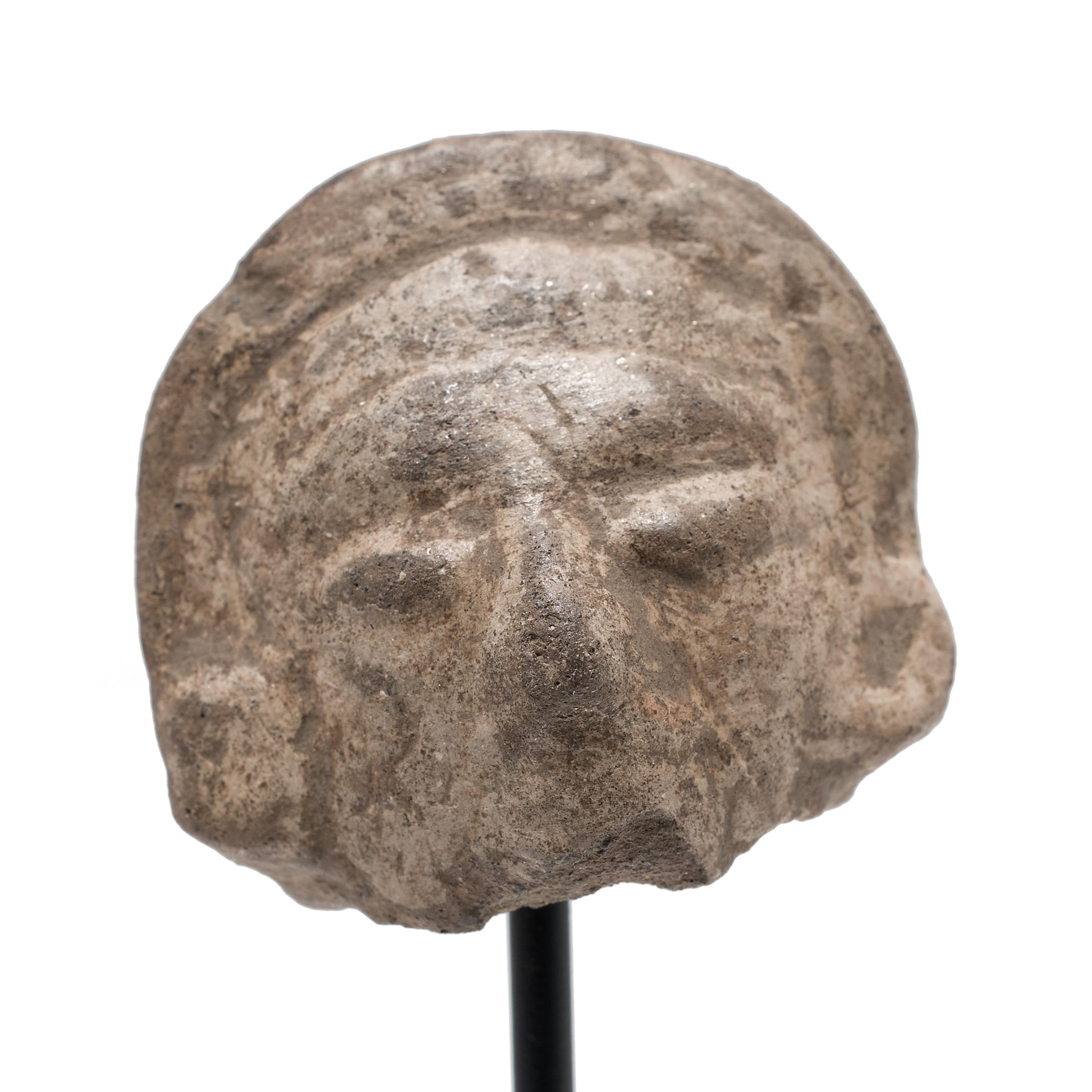 Dieses faszinierende Kopffragment war einst an einer prä-Columbianischen Büste oder Vollplastik angebracht. Steingutfiguren wie diese wurden im Laufe der mesoamerikanischen Geschichte in großer Zahl hergestellt und dienten einer Vielzahl von Zwecken