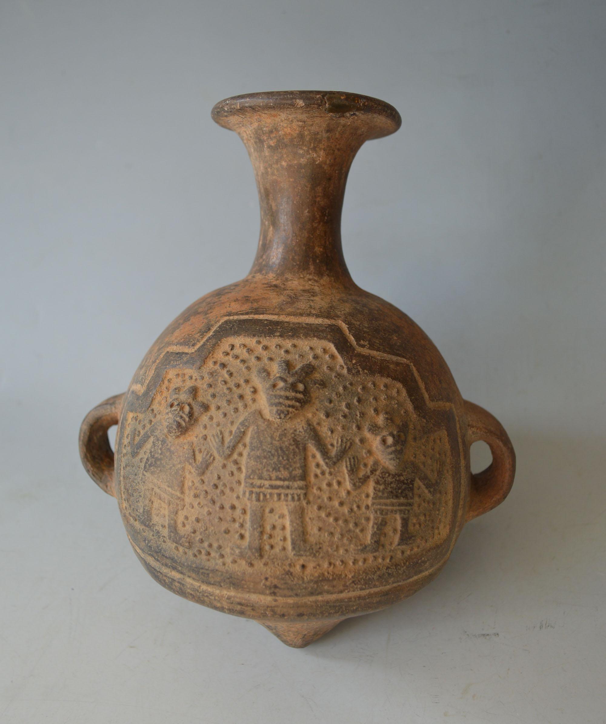 A Pre Columbian Chimu / Inca Aryballos
A Fine pointed bottom aryballos type vessel  In Grey pottery featuring a frieze of three masked dancing figures in a central cartouche.
Chimu Inca period Peru Circa 13-15th century AD,
Height 8.5 Inches 22
