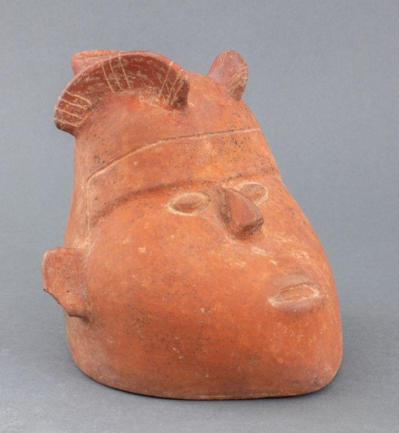 Ancient pre-Columbian, Colima, Mexican, circa 100 BCE to 250 CE, ceramic pottery redware vessel in the form of a head with rectangular ears and donning a headdress with incised geometric decoration, with a tapered spout. 6.5