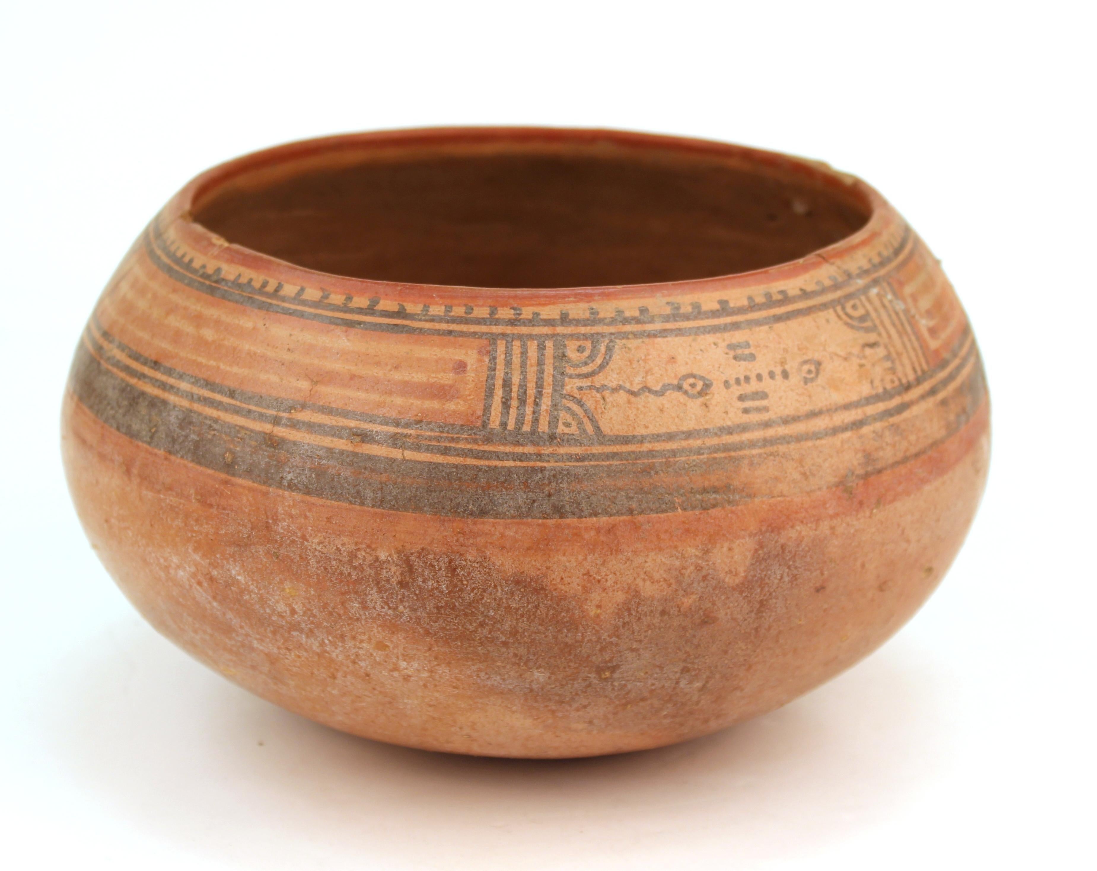 Pre-Columbian Nicoya pottery bowl from the Costa Rican Guanacaste Province, made in the 17th century. A round-bottomed red clay bowl painted with geometric designs and natural pigment decor in red and black. The piece has repaired old breaks and