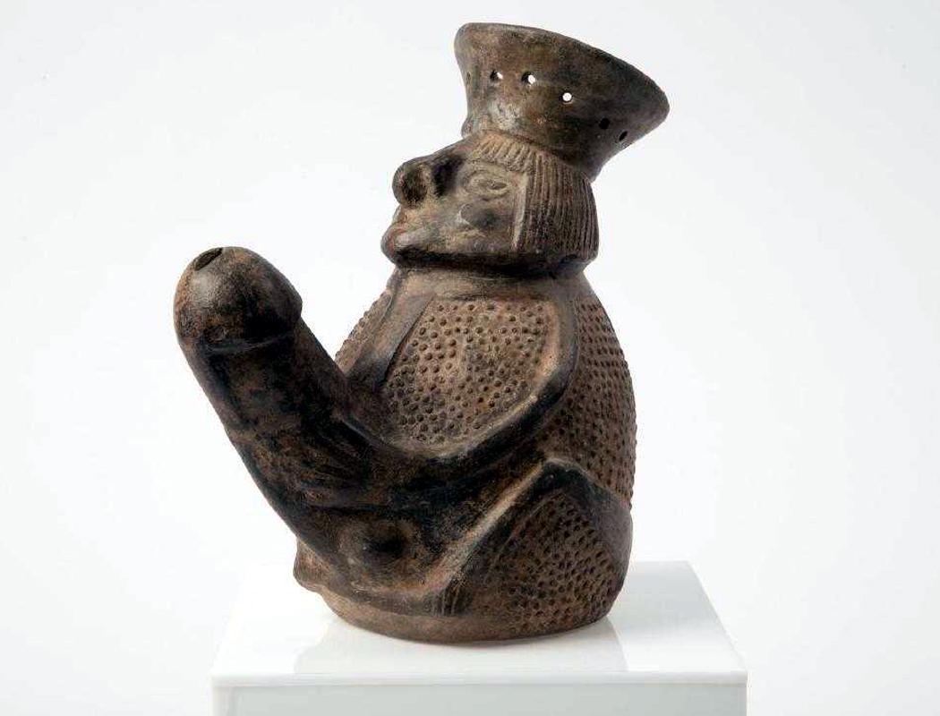 A striking homomorphic black pot, from the Chimu Culture (8th-15th century AD) along the Northern Coast of the nowadays Peru, of a jug form as a man with an exaggerated phallus. Well molded face and expertly outlined limbs. The surface is decorated