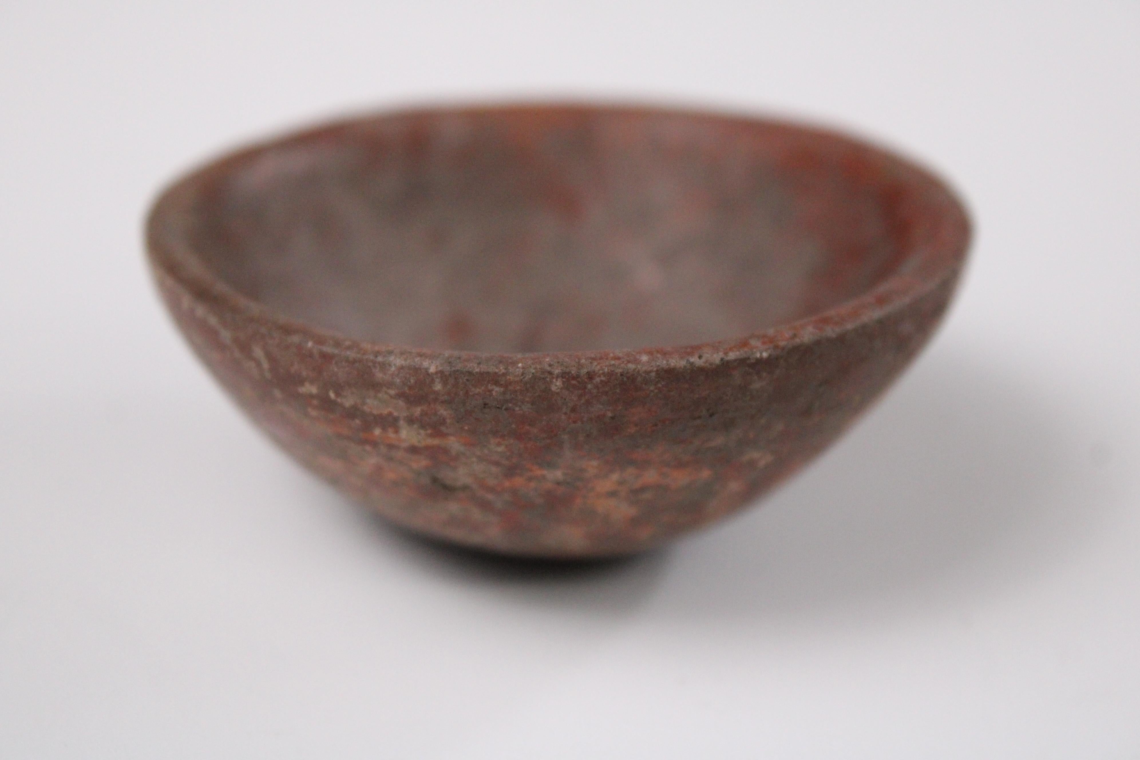 A rare and charming collection featuring a miniature polychrome pottery bowl from the ancient Jalisco culture (West Mexico, circa 200 BCE – 400 CE), accompanied by three carved stone labrets. 

The bowl showcases traditional form and decoration with