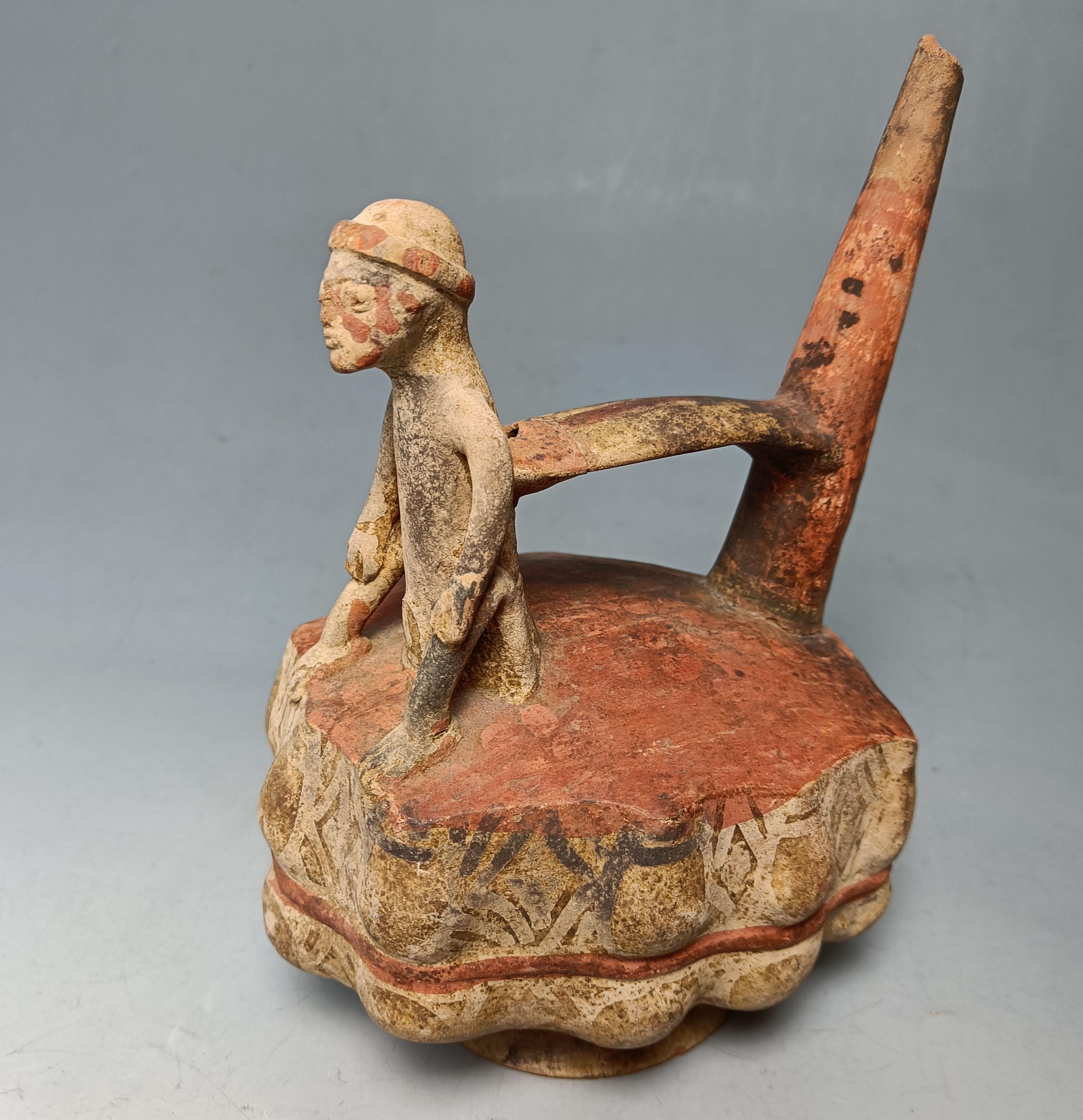 Pre Columbian Sican Lambayeque Stirrup whistle Vessel  
A most interesting stirrup whistle vessel of a man seated on top of a raft of storage vessel, the vessel features a conical spout that creates a high-pitched whistling sound from the opposite