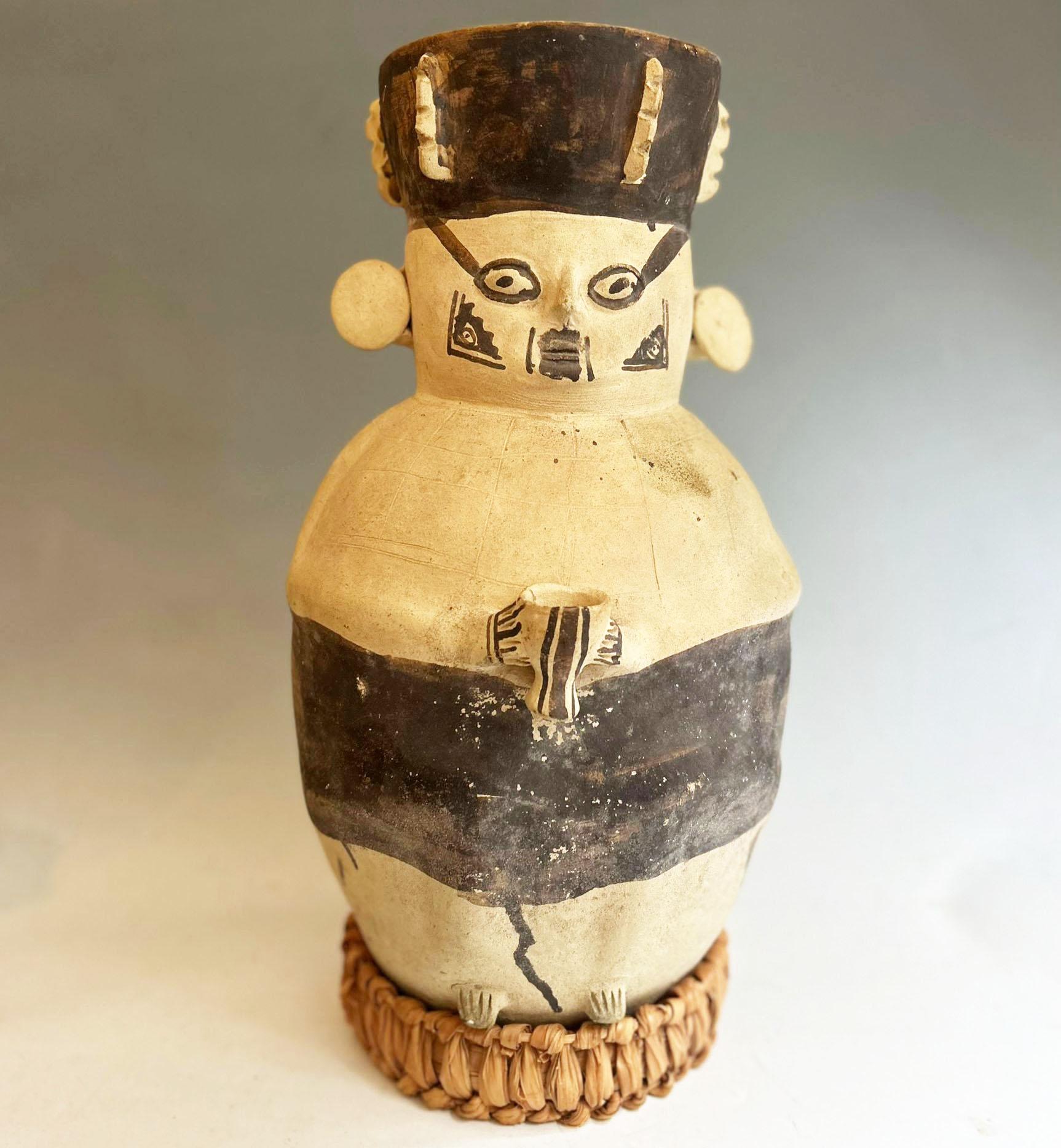 Large Chancay Anthropomorphic Urn Vessel

Pre-Columbian, Central Coast of Peru  1000–1450 CE

An imposing and characterful Chancay culture ceramic urn, fashioned in the form of a stylized human figure. This large vessel, typical of the Late