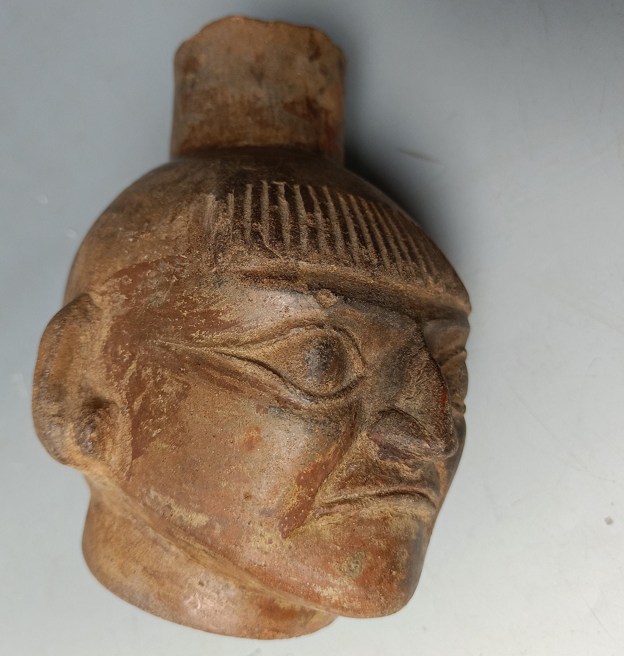 A Pre columbian Moche portrait Vessel
A  vessel modelled on a Amazonian native American Indian, a personage with a grimacing face perhaps a prisoner the shaved head and fringe is typical of indigenous Amazonian tribes, who wear this hair style, with