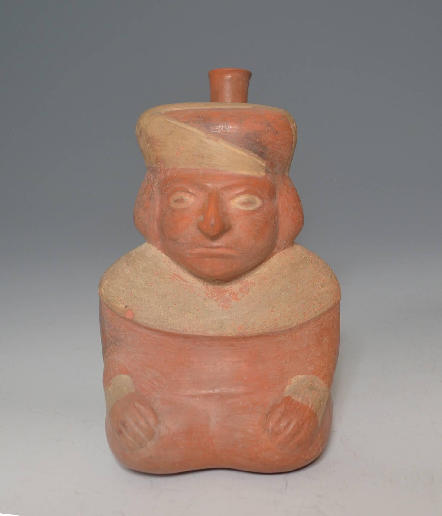 Pre-Columbian art
A Moche vessel of a seated personage with with fixated gaze probably representing hallucinogen induced state  
The seated figure with geometric head dress and cream yoke collar with stirrup spout at rear
Moche culture, circa