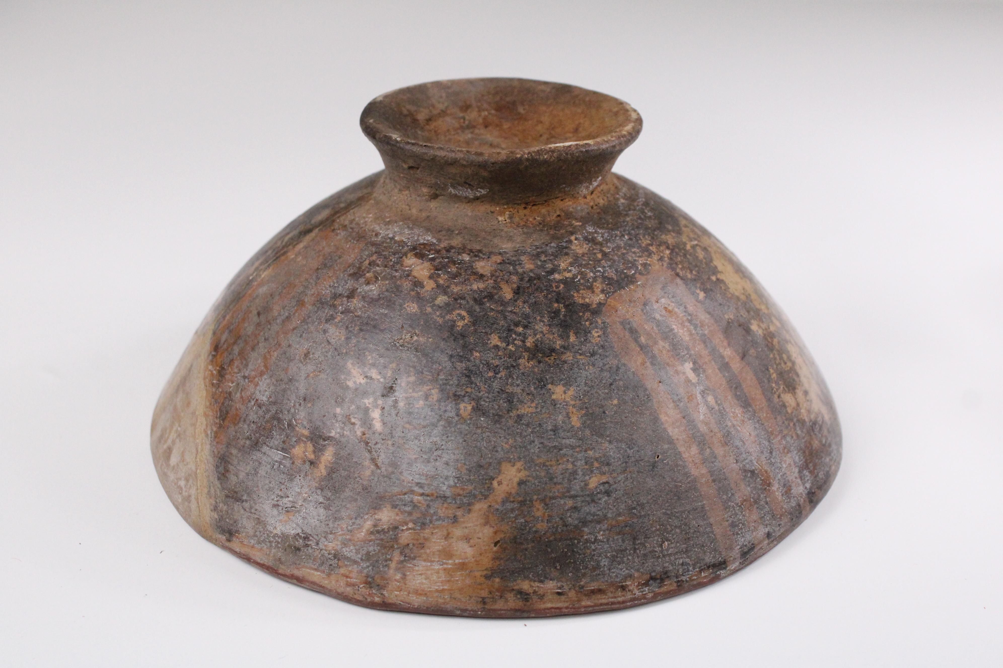 A striking example of Pre-Columbian artistry, this footed bowl hails from the Nariño culture of southern Colombia, dating from 850–1500 AD. Crafted with a rich red-orange slip and adorned in bold, intricate black and white geometric motifs, the bowl