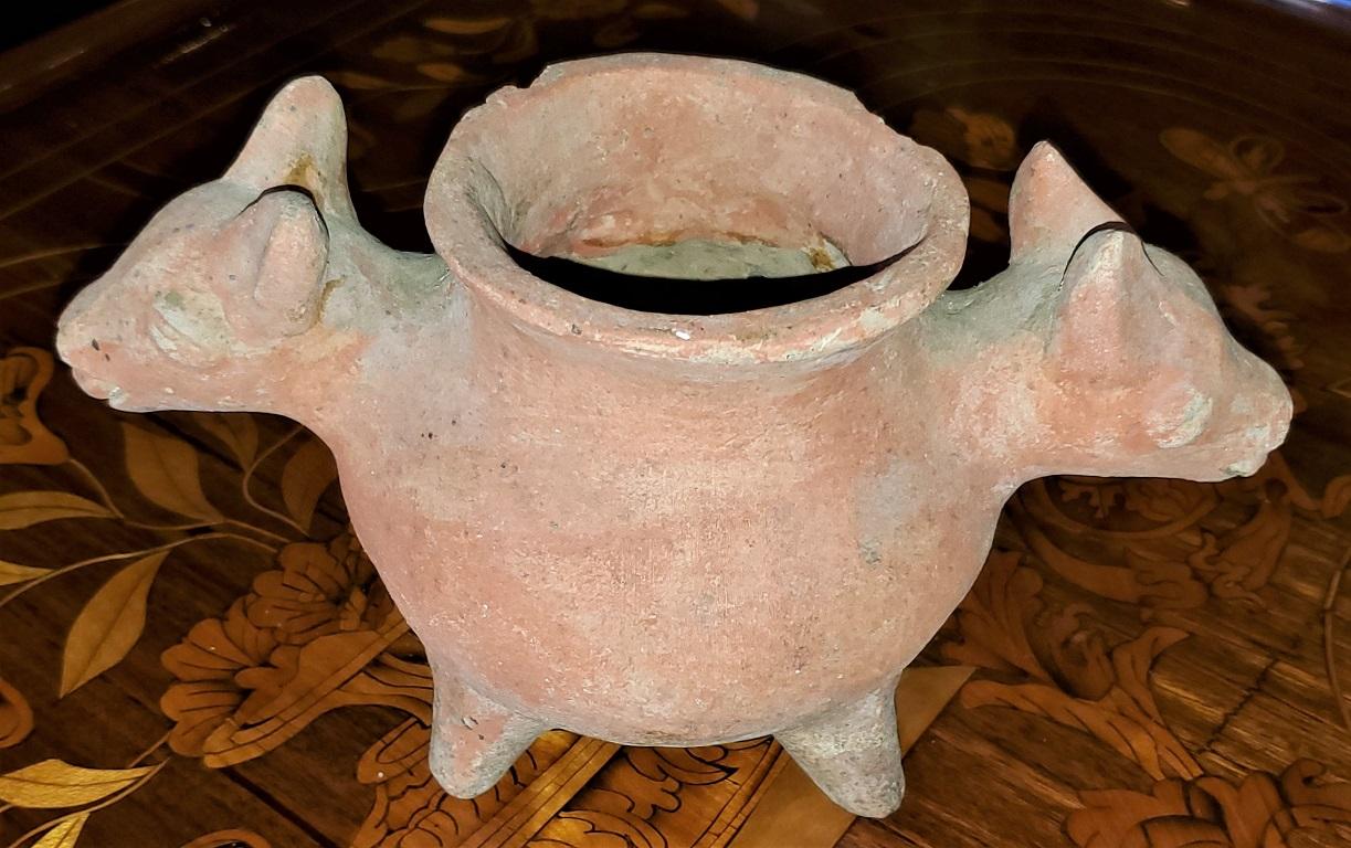 Presenting a lovely representation of a Native American antiquity, namely, a Pre-Columbian Style pottery vessel with cat or coyote heads.

Most likely a 20th Century copy.

It appears to be a form of terracotta style pottery.

The bowl is very