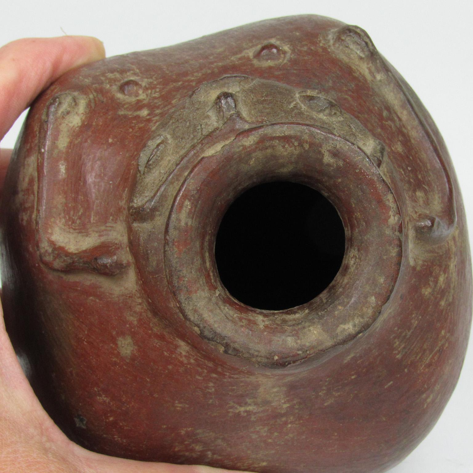 Pre-Columbian redware vessel, possibly Peruvian. An open vase in the form of a female with arms embracing the bulbous body. Kiln firing residue still visible. Measures: Height 4 1/2 in., diameter 4 in.