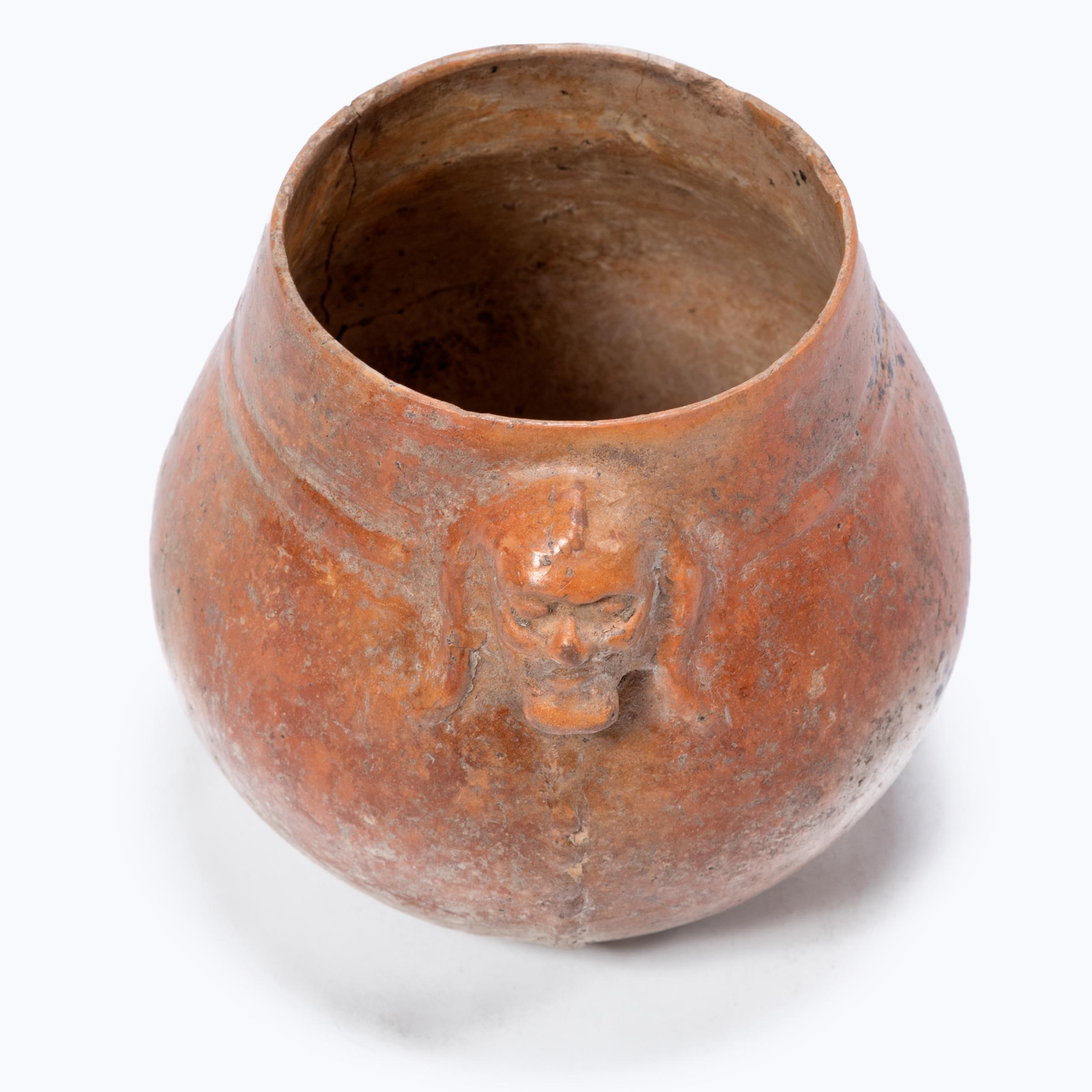 Exhibiting a rich patina, this petite redware vessel shows many telltale signs of Pre-Columbian pottery. Speckled with imperfections, the vessel's warm red-orange coloration was achieved by applying a mineral-rich slip for a monochrome finish.