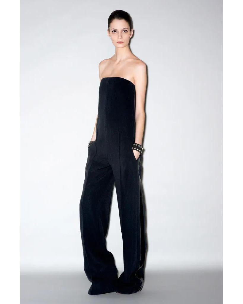 Pre-Fall 2011 Céline by Phoebe Philo black strapless jumpsuit. Black silk drop waist jumpsuit with pin-tucked wide leg trouser and built-in corset with leather contrast side paneling. Hidden back zip closure and functional side pockets. As seen in