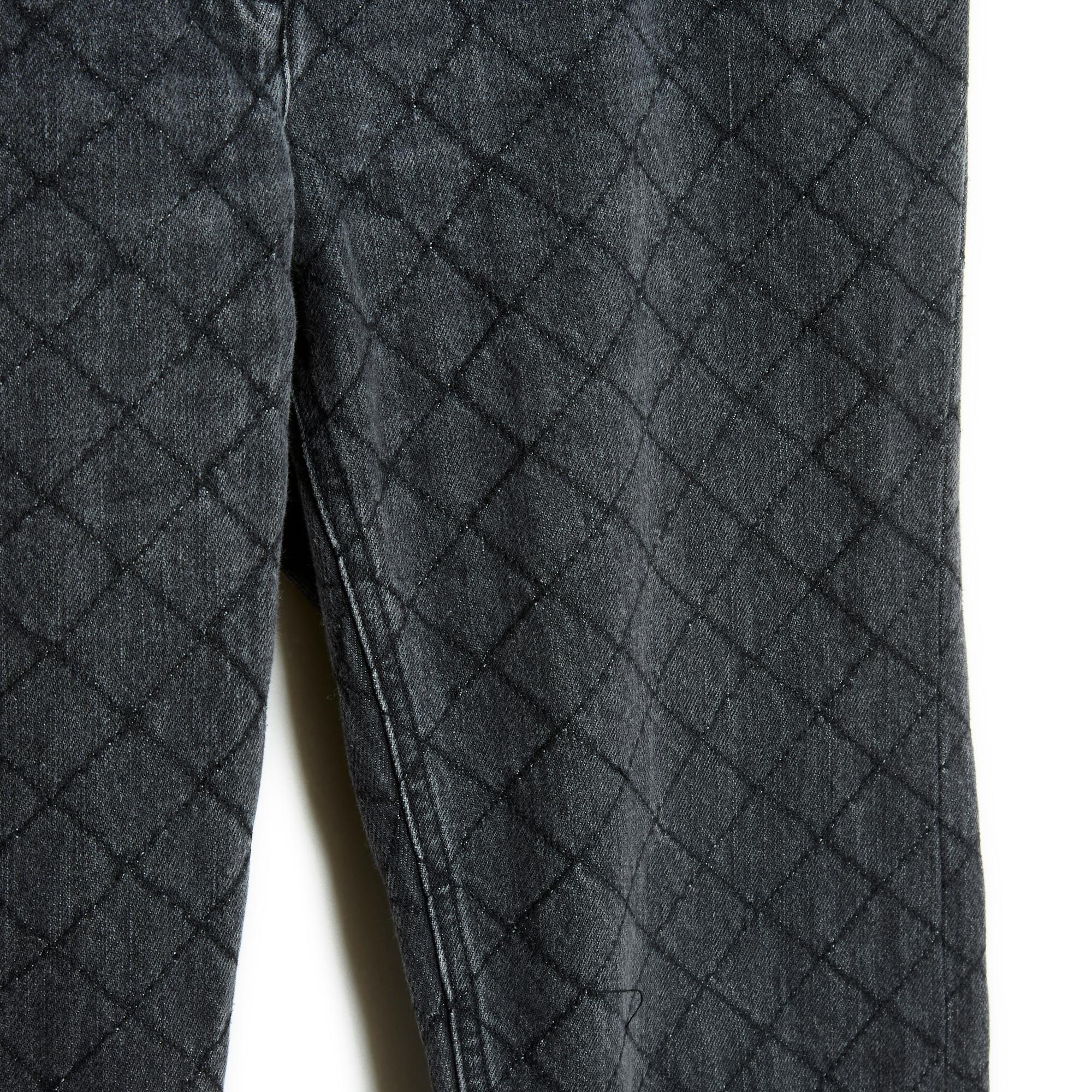 Jean Chanel collection Pre Fall 2012 - Paris Bombay - en toile denim noire légèrement délavée et matelassée de surpiqûres en épais fil noir, comme le 2.55, coupe droite, poches jean, ceinture à passants, fermé par un zip et un bouton de marque CC.