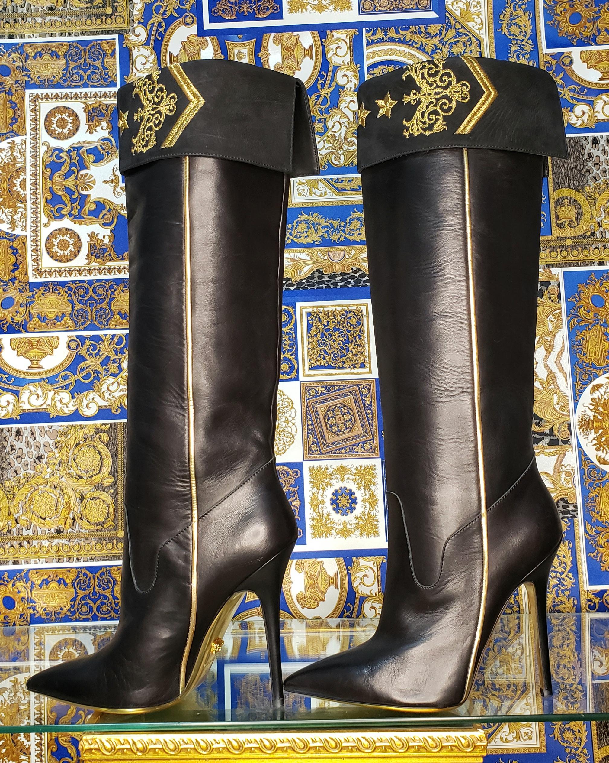 VERSACE



Actual PR-sample Pre-Fall 2013 Look # 8 



Black leather knee boots



Pointed toe,  metallic trim, gold embroidery and a tonal covered stiletto heel.



Pull on



Content: 100% Leather

Sole: Leather 



Heel height approx. 5