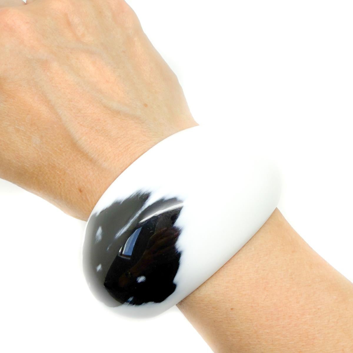 Un bracciale monocromatico Hermès usato. Colpisce per il suo classico design monocromatico. Un articolo della linea Corne et Laque di Hermès, nata dall'accostamento di due tecniche artigianali tradizionali le cui origini affondano nel cuore