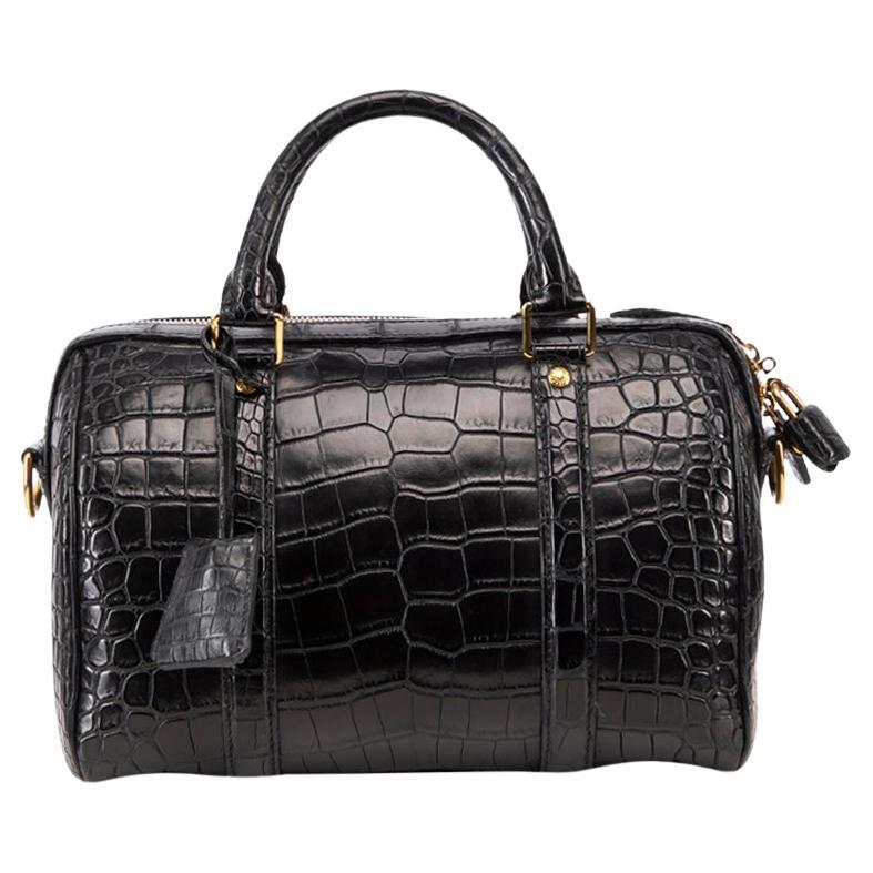 Woman with Louis Vuitton black crocodile leather bag before Gucci
