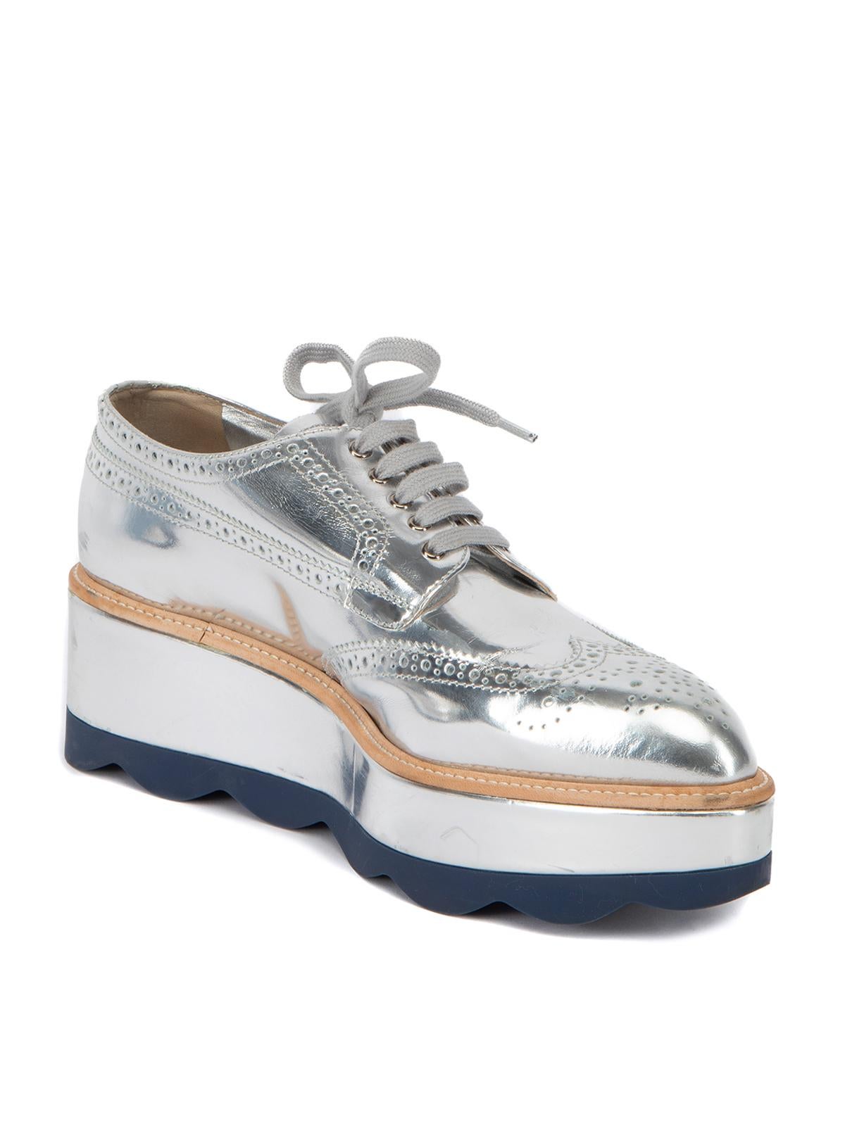 CONDITION is Very good. Minimal wear to shoes is evident. Minimal scuffs and crease marks to the exterior on this used Prada designer resale item. This item comes with the original dustbag and shoebox. Details Metallic Silver Patent leather Brogue