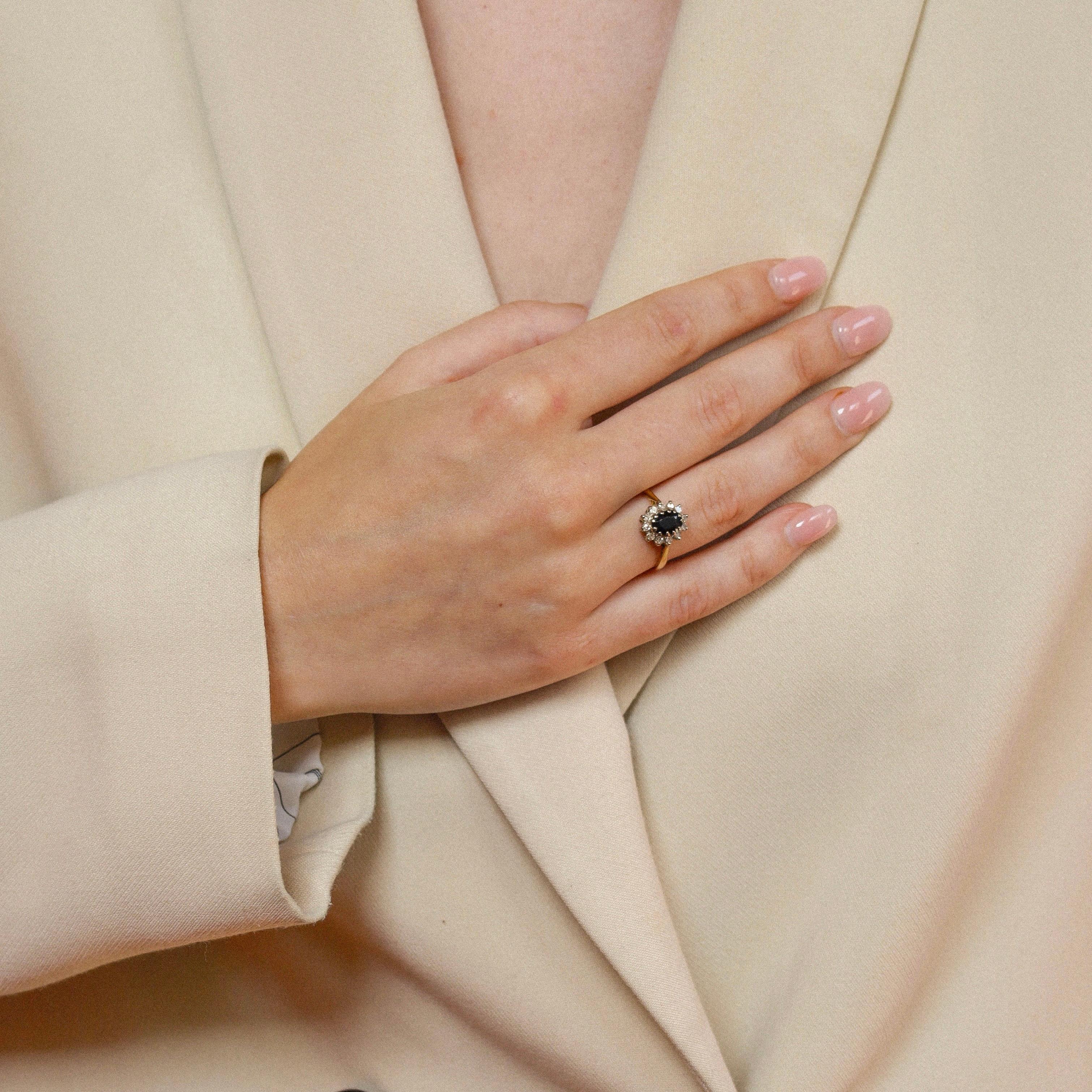 Oval Cut Pre-loved ring made of 18 carat gold with sapphire surrounded with 12 diamonds
