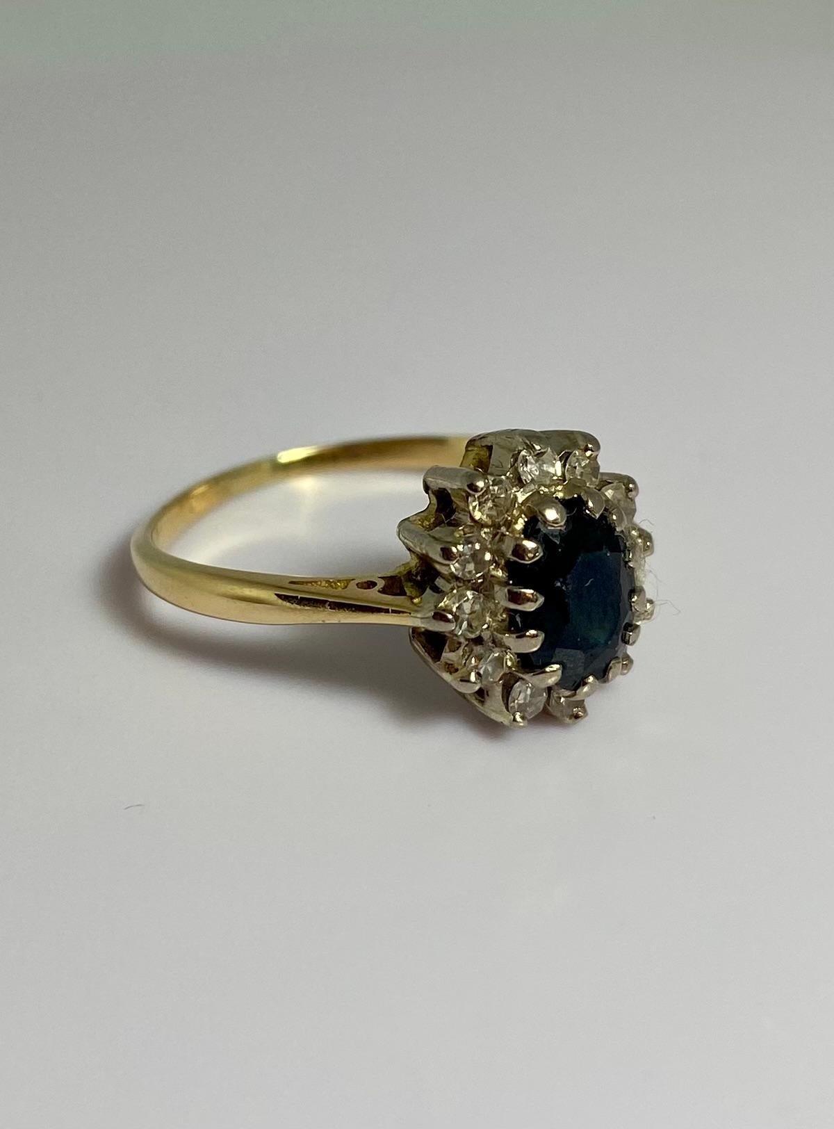 Pre-loved ring made of 18 carat gold with sapphire surrounded with 12 diamonds In Good Condition For Sale In Heemstede, NL