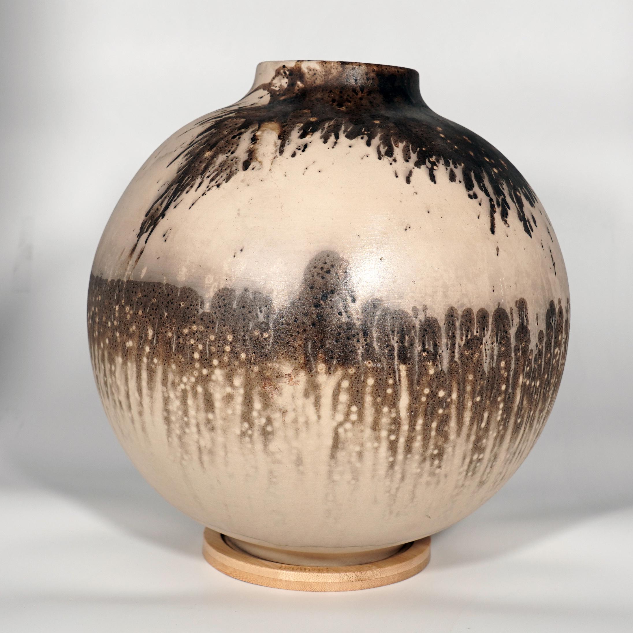 Die große Raku-gebrannte Vasen-Serie von RAAQUU.

Diese Kugelvase ist ein rundes, geräumiges Stück, das in der Raku-Technik hergestellt wird, was zu einer schönen, unvorhersehbaren Oberfläche führt. Diese Vase eignet sich hervorragend als