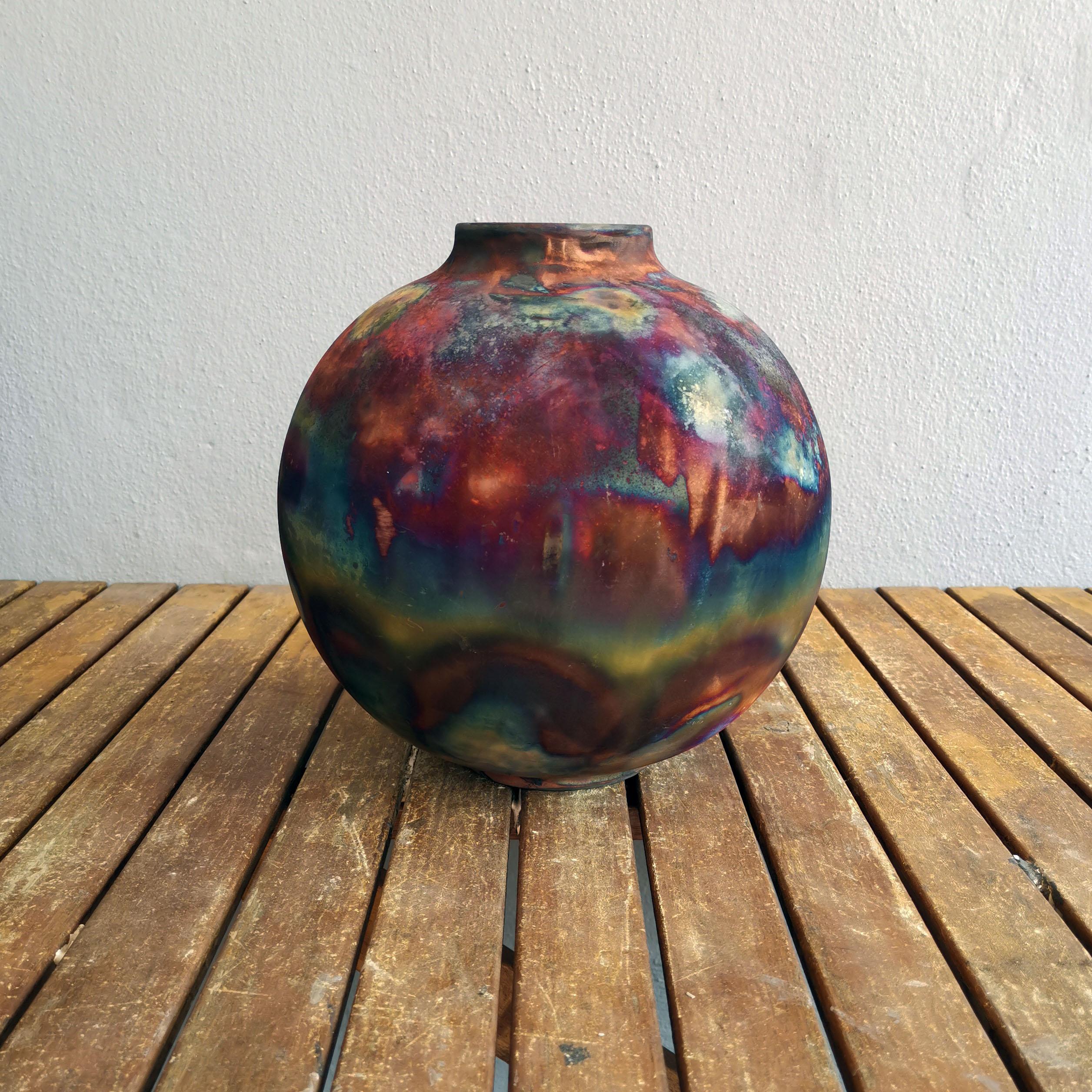 Le grand vase cuit en Raku Centerpiece Series de RAAQUU.

Un spectacle fascinant à contempler dès que les patines en forme d'arc-en-ciel attirent votre attention.

Ce vase Globe est une pièce ronde et volumineuse produite à l'aide de la technique