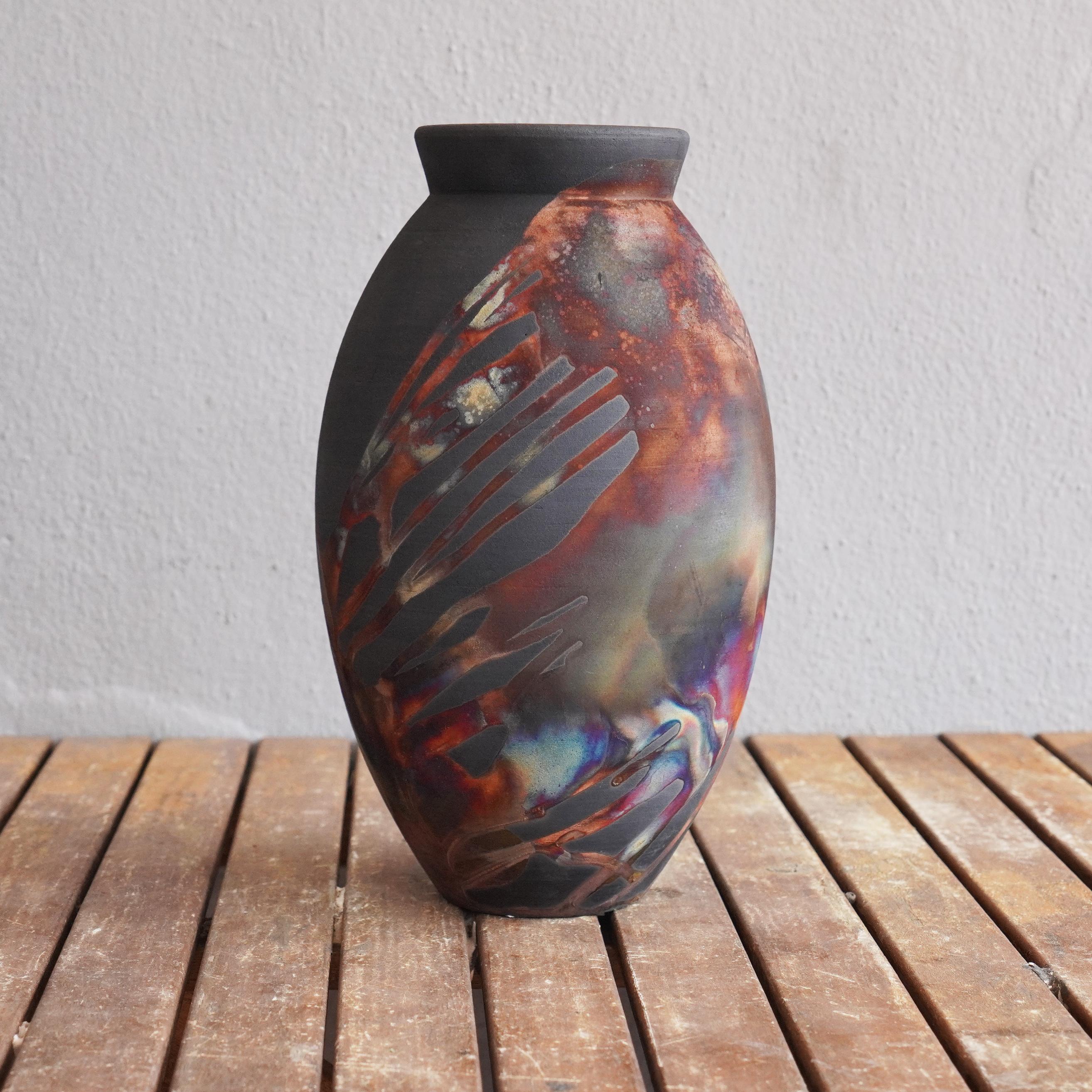 The large raku fired vase centerpiece series by RAAQUU.

A mesmerizing sight to behold as soon as the rainbow-like patinas catch your eye.

The Oval Vase is a tall, teardrop-shaped design best for adding a touch of elegance and intrigue to an