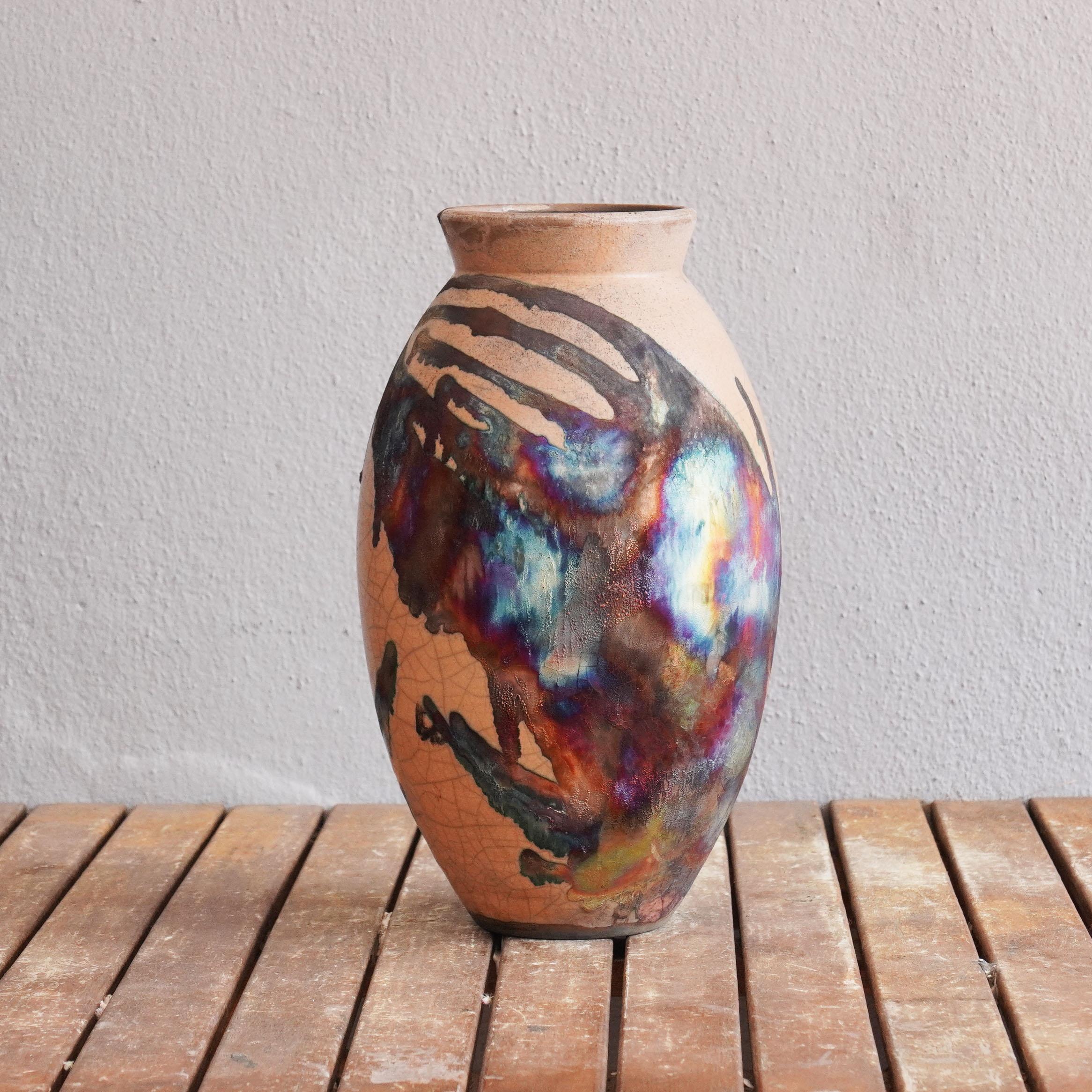 The large Raku fired vase centerpiece Series by RAAQUU.

A mesmerizing sight to behold as soon as the rainbow-like patinas catch your eye.

The Oval Vase is a tall, teardrop-shaped design best for adding a touch of elegance and intrigue to an