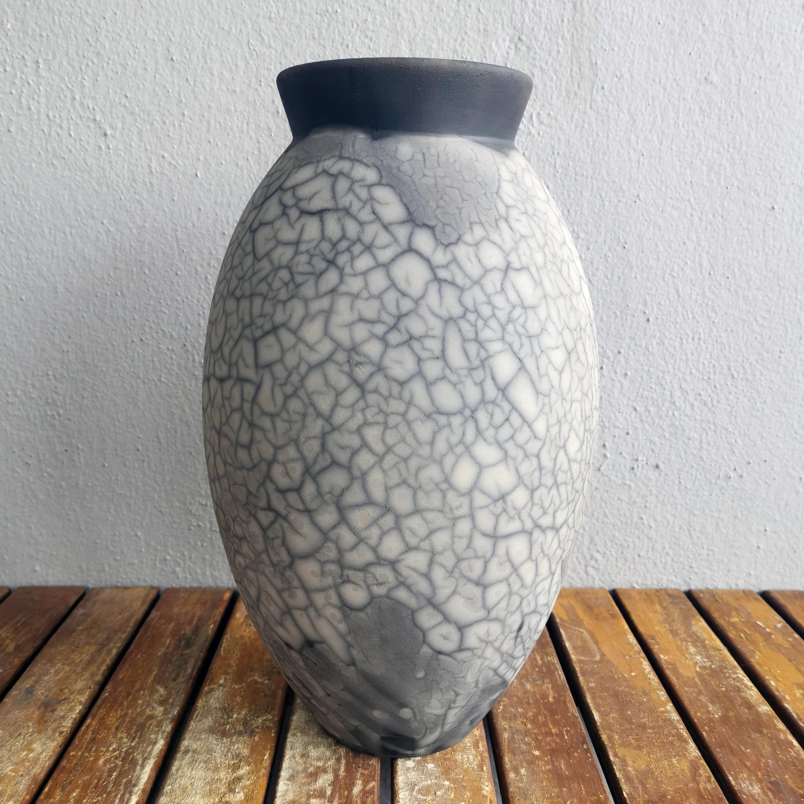 The Large Raku fired vase centerpiece Series by RAAQUU.

The Oval Vase is a tall, teardrop-shaped design best for adding a touch of elegance and intrigue to an interior space. Made using the Raku technique, it easily becomes a great conversation