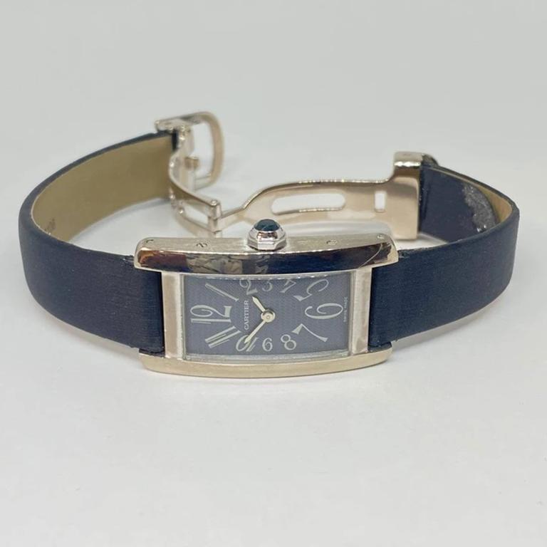 Pre-owned lady's small Cartier Tank Americaine designed in 18 karat white gold. The watch measures 19 x 34.5mm, faceted blue crown, arabic numerals, grey dial, no second hand. Cartier satin grey leather strap, please see wear in pictures. Strap