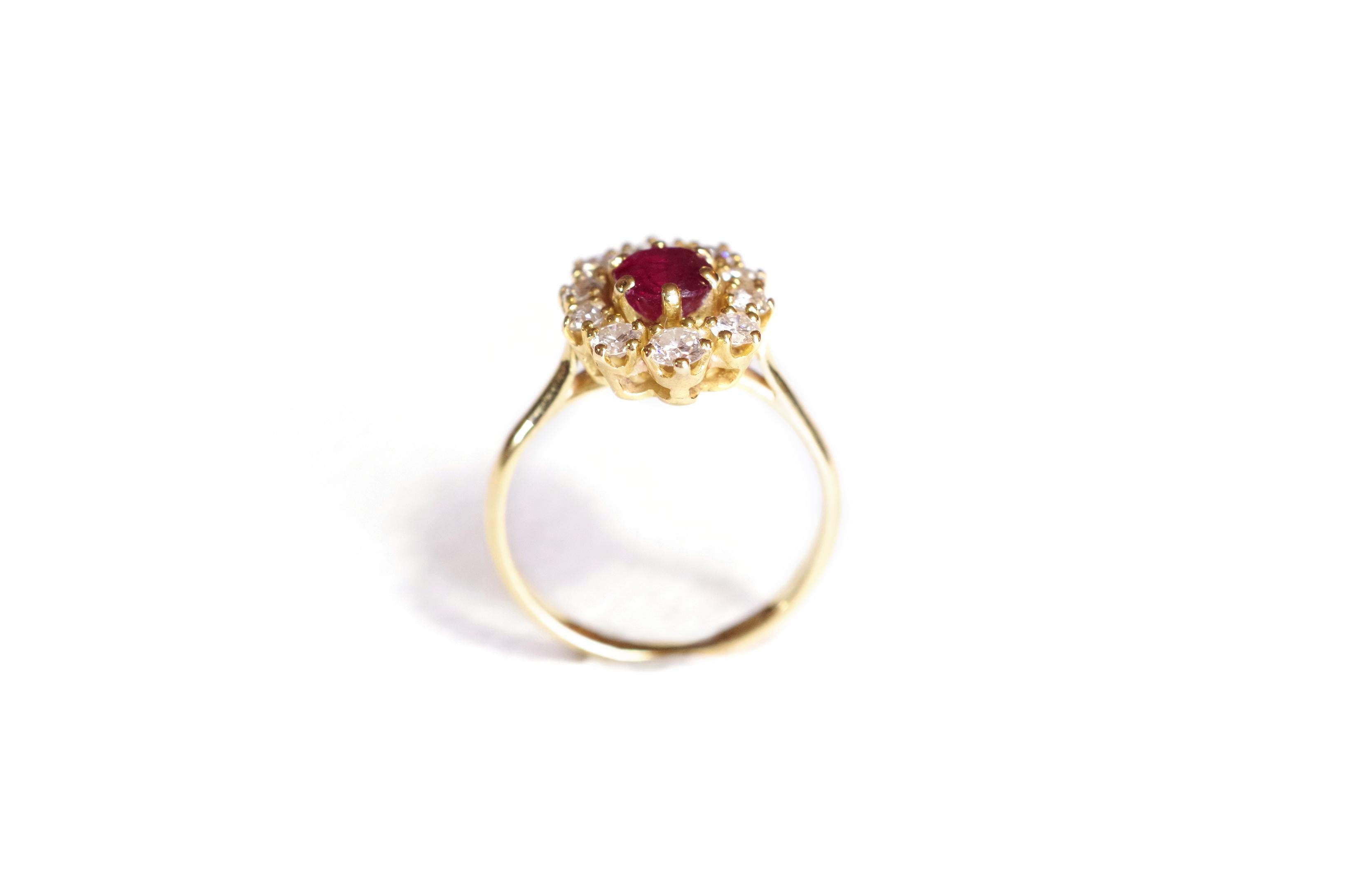 Ruby and diamond cluster ring in 18 karat yellow gold centered with a cushion ruby (treated with enhancement) of approximately 0,54 carat, surrounded by 10 brilliant-cut diamonds. 
French work, 20th century.

Partially marked eagle's head