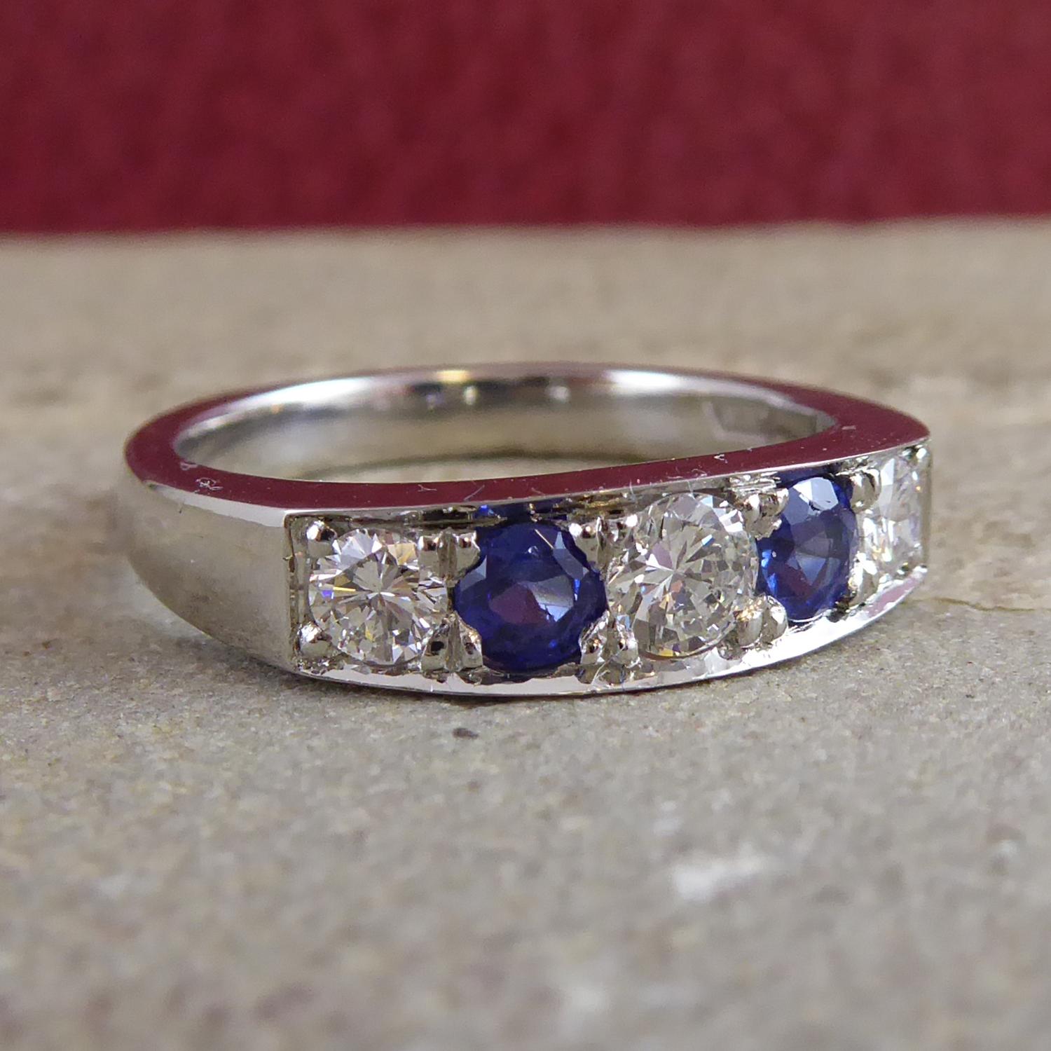A diamond and sapphire five stone eternity ring set with graduating round brilliant cut diamonds, measuring from approx. 3.70mm to 3.10mm in diameter.  The diamonds alternate with two round, mixed cut sapphires, each measuring approx. 3.30mm and